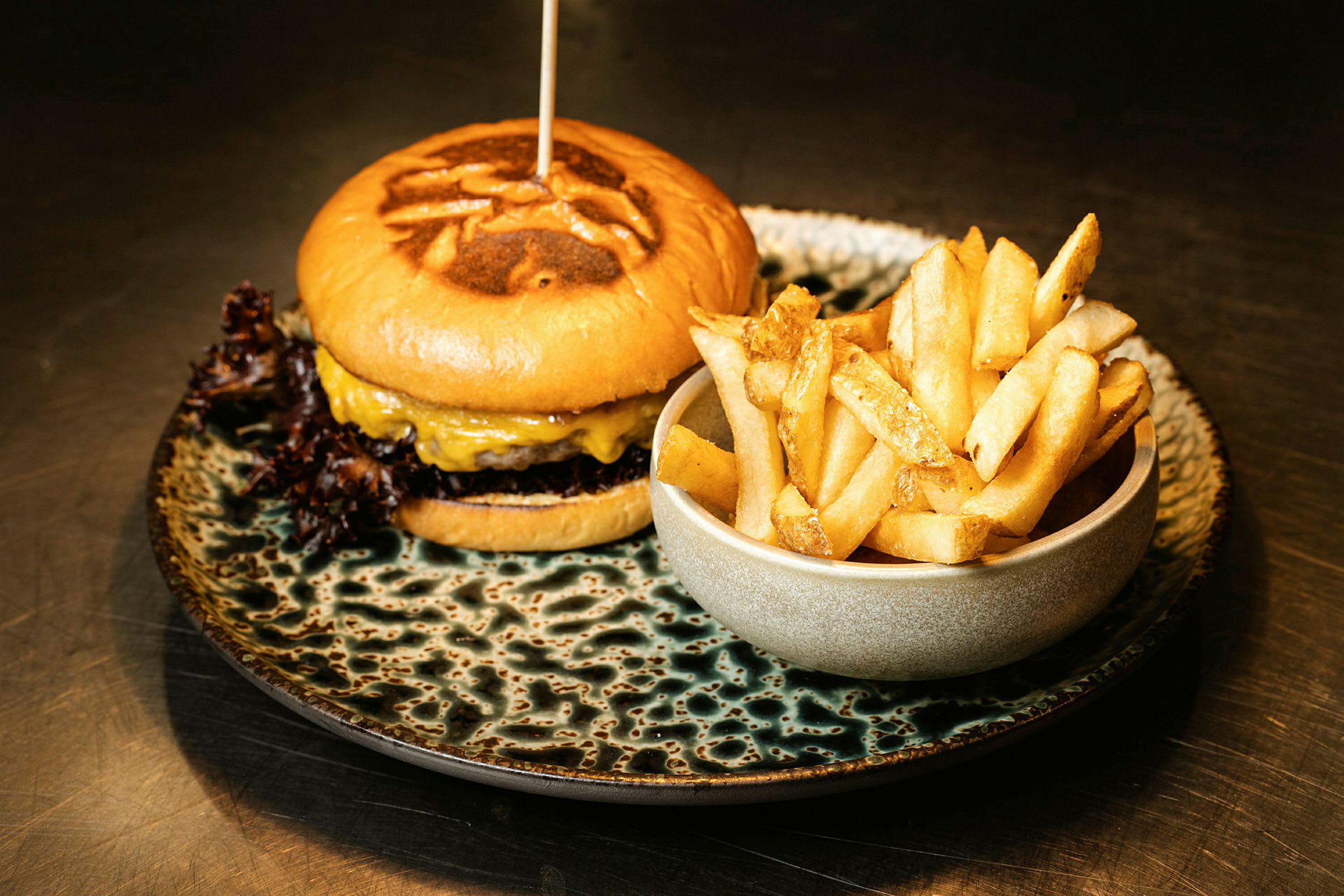 Bilde av en hamburgertallerken med pommes frites. (AI-generert tekst)