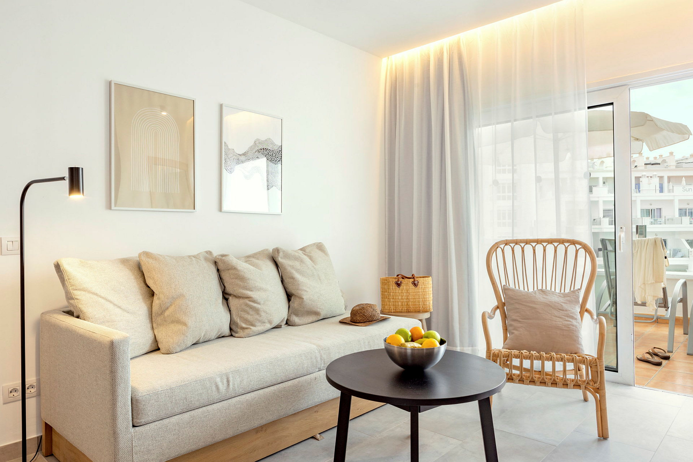 Moderne innredet stue med sofa, lenestol og bord foran en balkong. (AI-generert tekst)