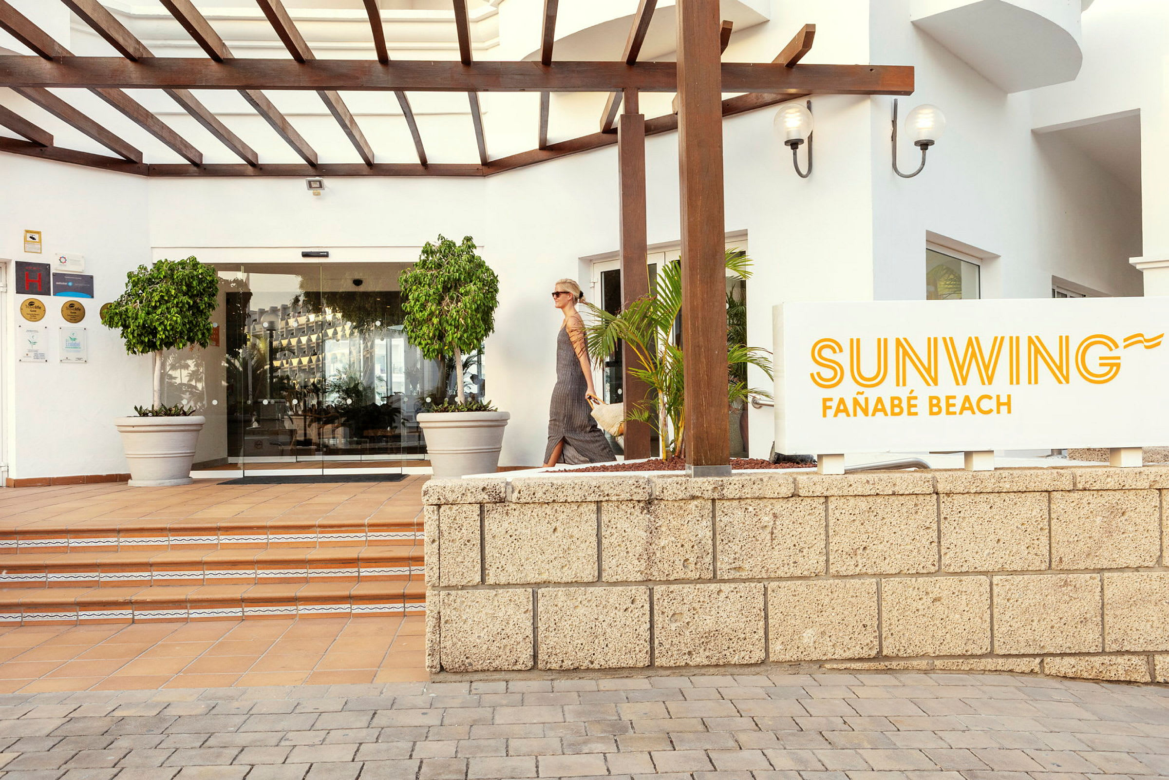 Inngangen til Sunwing Fañabé Beach med skilt og glassdører. (AI-generert tekst)