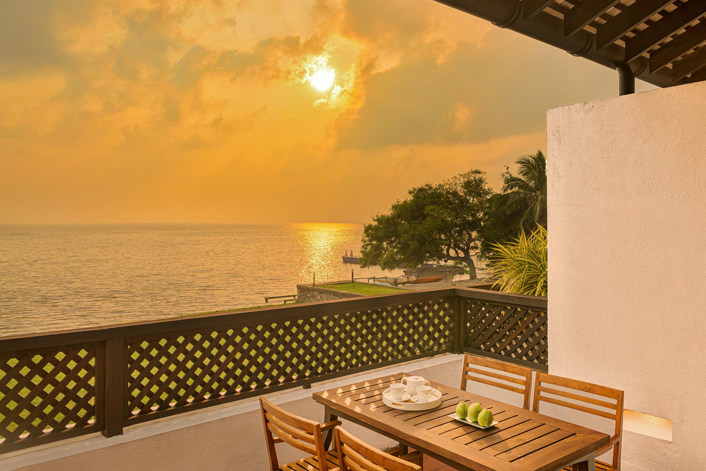 Utsikt fra en terrasse mot en solnedgang over havet. (AI-generert tekst)