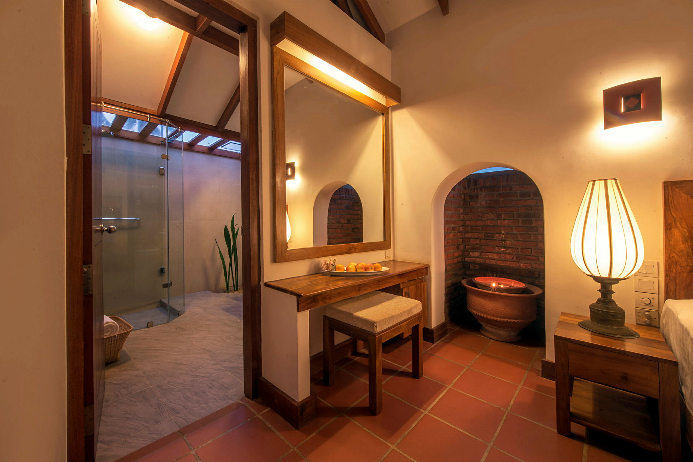 Et varmt belyst rom med speil, lampe og tilgang til et moderne bad. (AI-generert tekst)