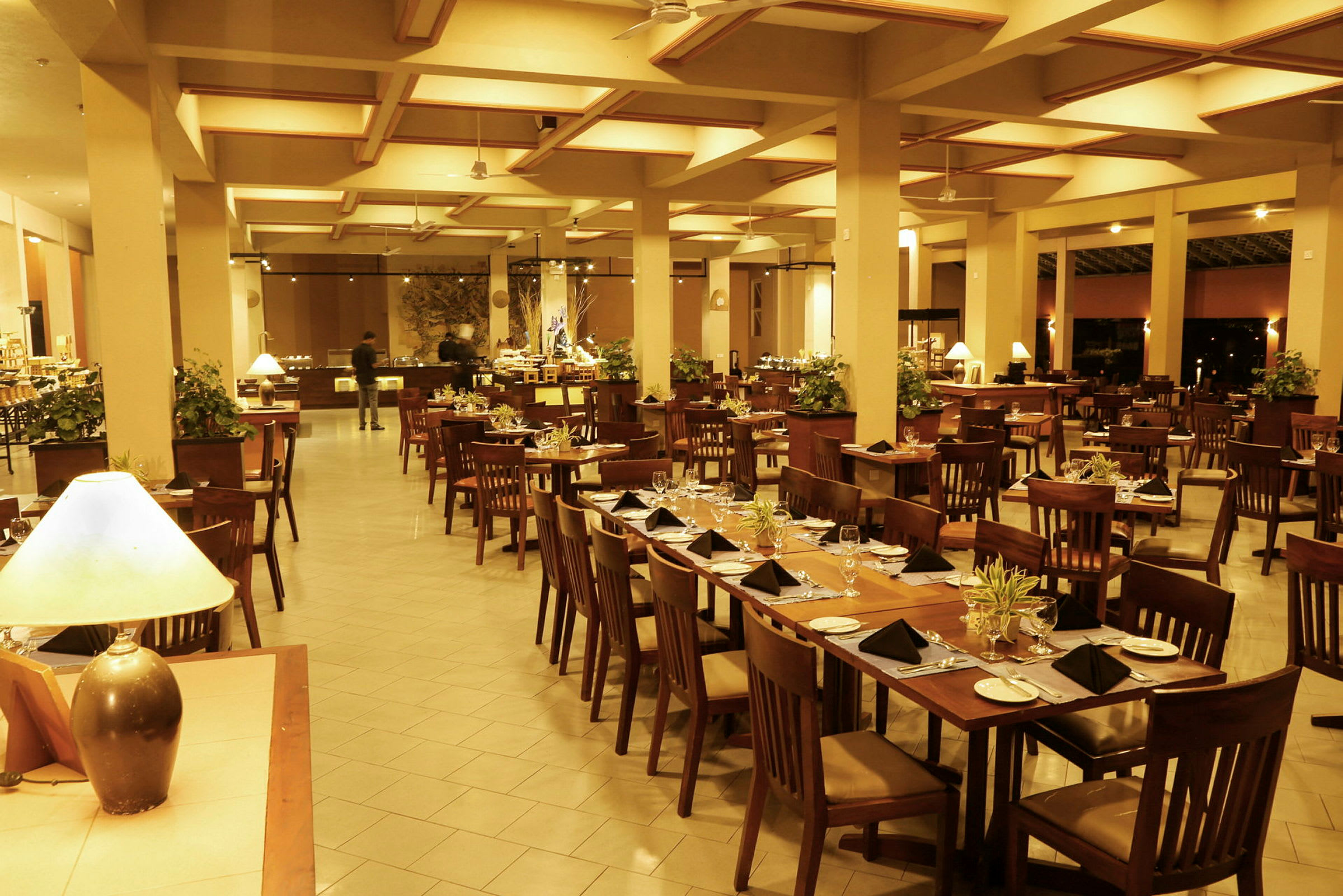 Stort område med en restaurant, bord og stoler for gjester samt en buffet i bakgrunnen. (AI-generert tekst)