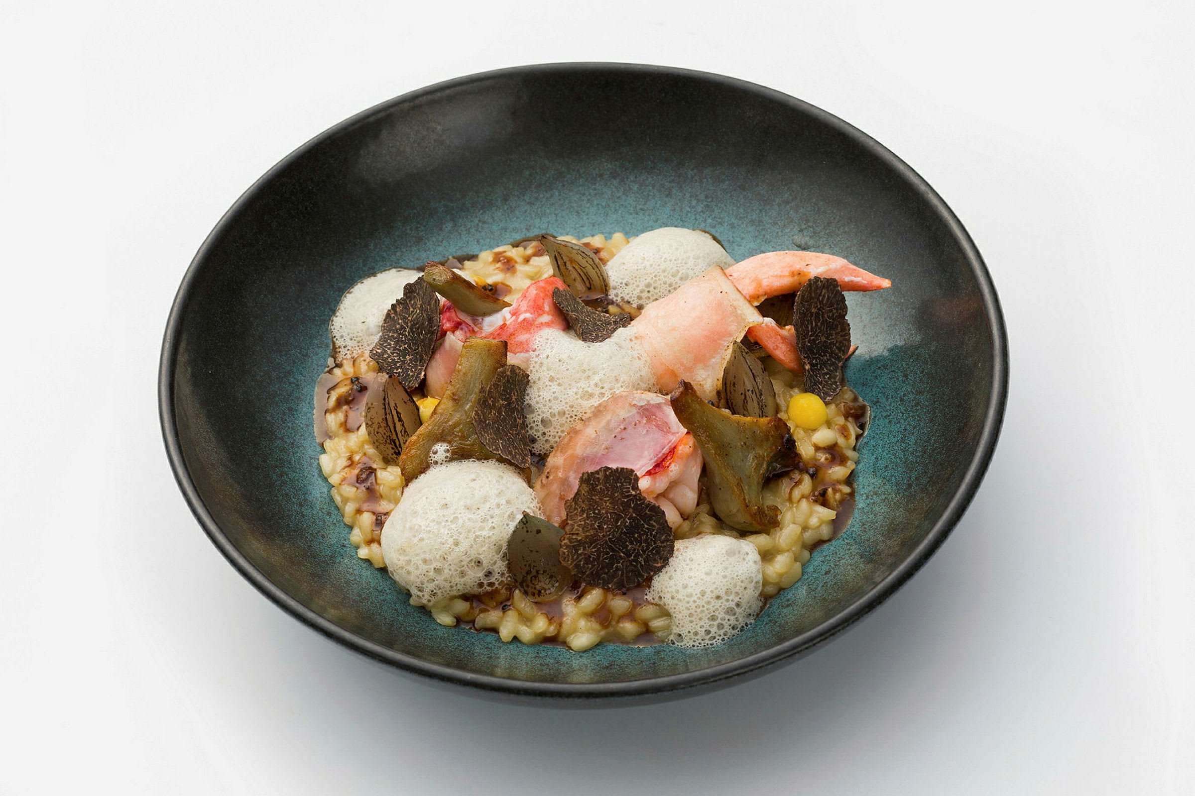 En tallerken med en elegant matrett som inneholder skalldyr, sopp og en skummede saus. (AI-generert tekst)