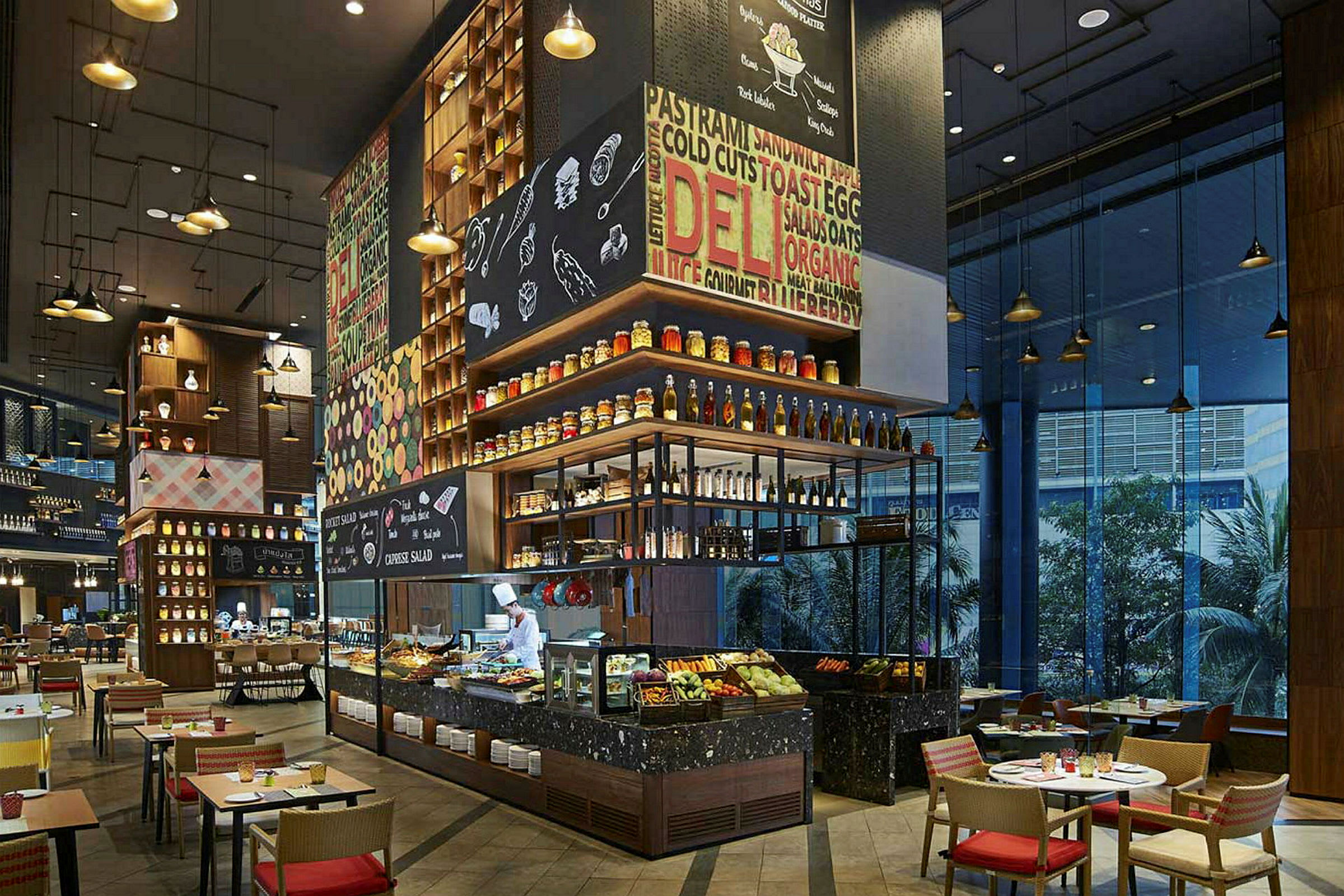 En moderne restaurant med stilig innredning. Det er et åpent kjøkken, en buffet med mat og drikke samt bord og stoler for sitteplasser. (AI-generert tekst)