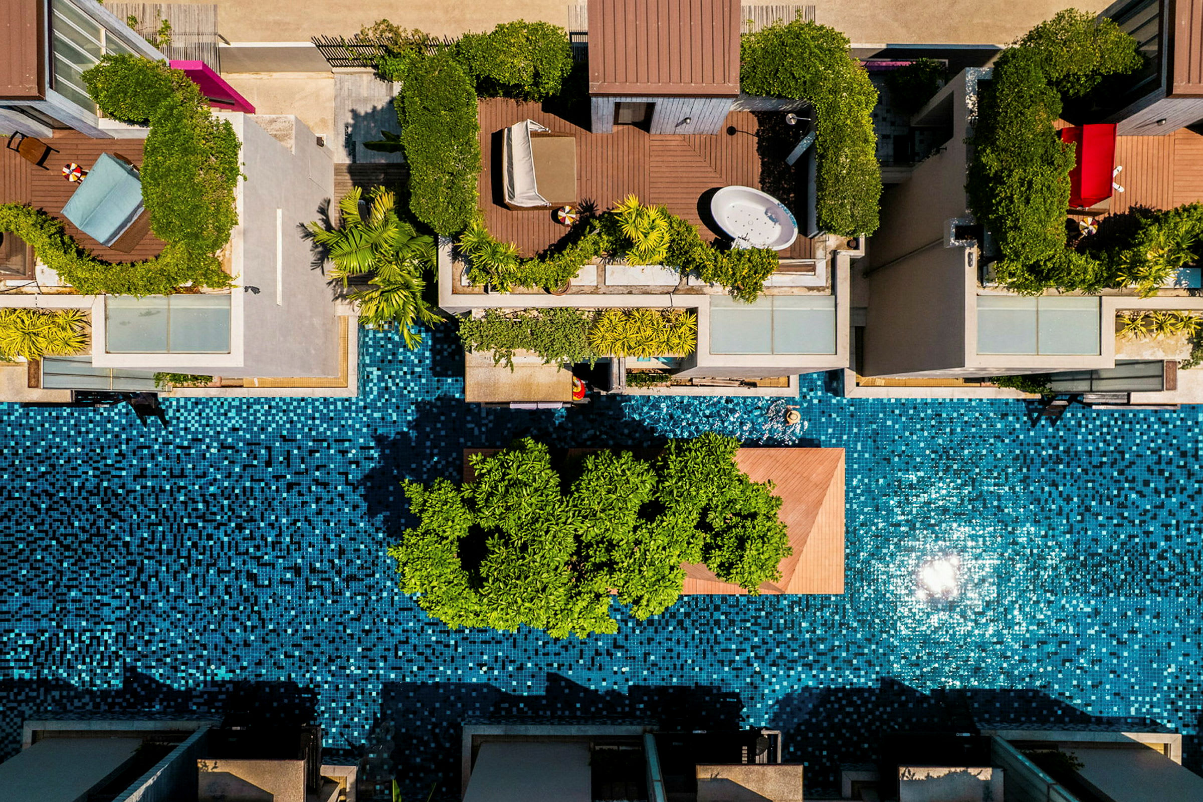 Flyfoto av moderne boliger med private terrasser og bassengområde. (AI-generert tekst)