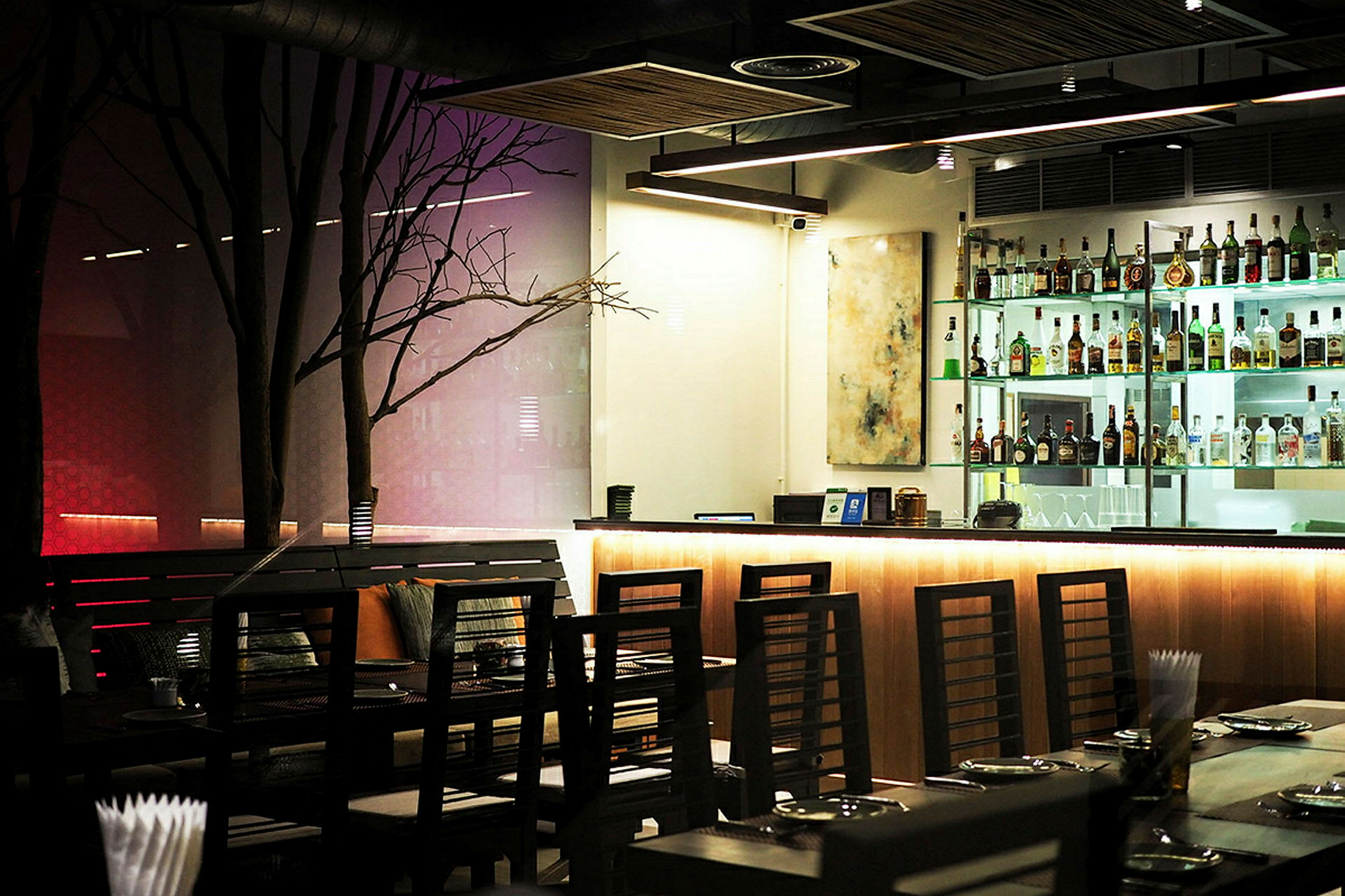 En moderne bar og restaurant med opplyst bardisk og stilige møbler. (AI-generert tekst)