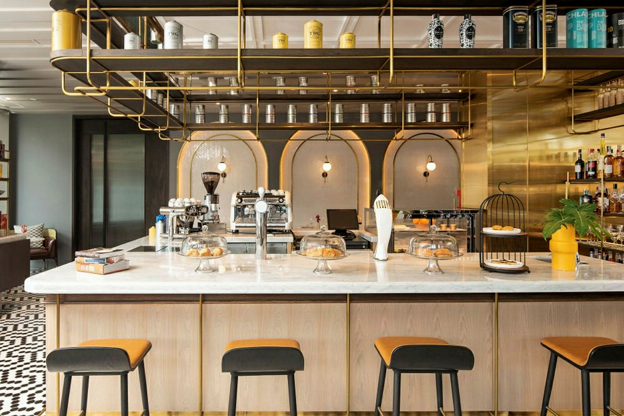 En elegant kafé med moderne interiør, en marmorbar, høye stoler og hyller dekorert med bokser og flasker. (AI-generert tekst)