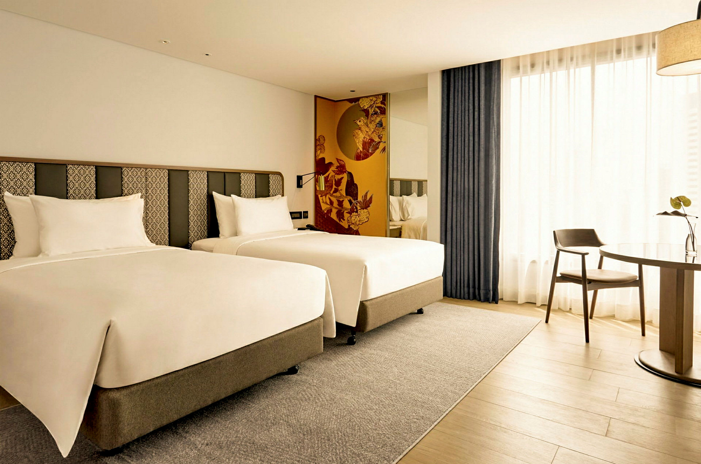 Hotellrom med to enkeltsenger og et bord med en stol. (AI-generert tekst)