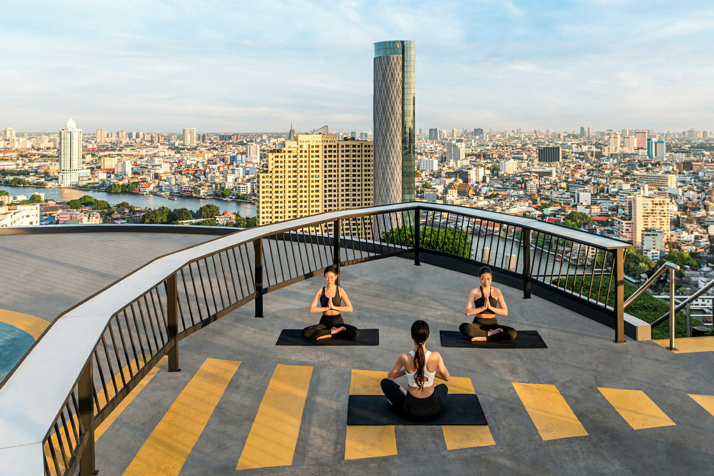 Personer som utfører yoga på en takterrasse med utsikt over en by. (AI-generert tekst)