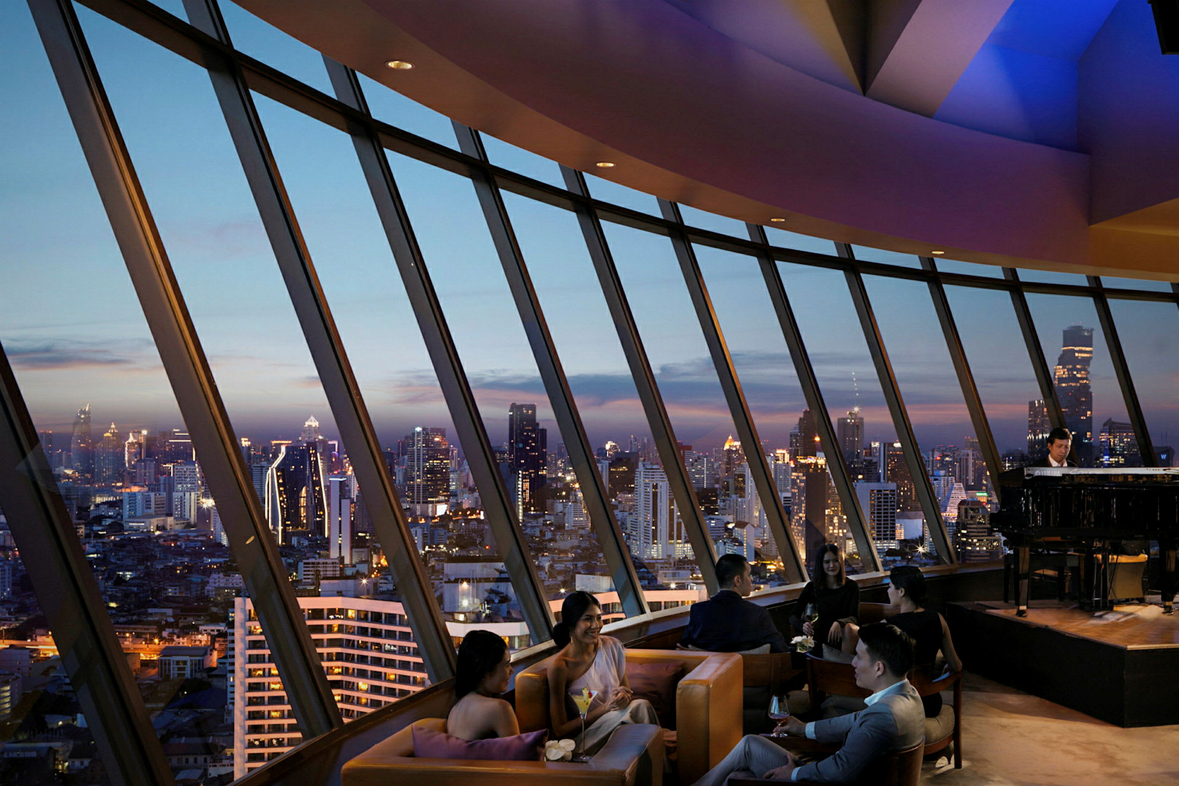 Folk sitter i en luksuriøs lounge med panoramautsikt over byens skyline ved skumring. (AI-generert tekst)