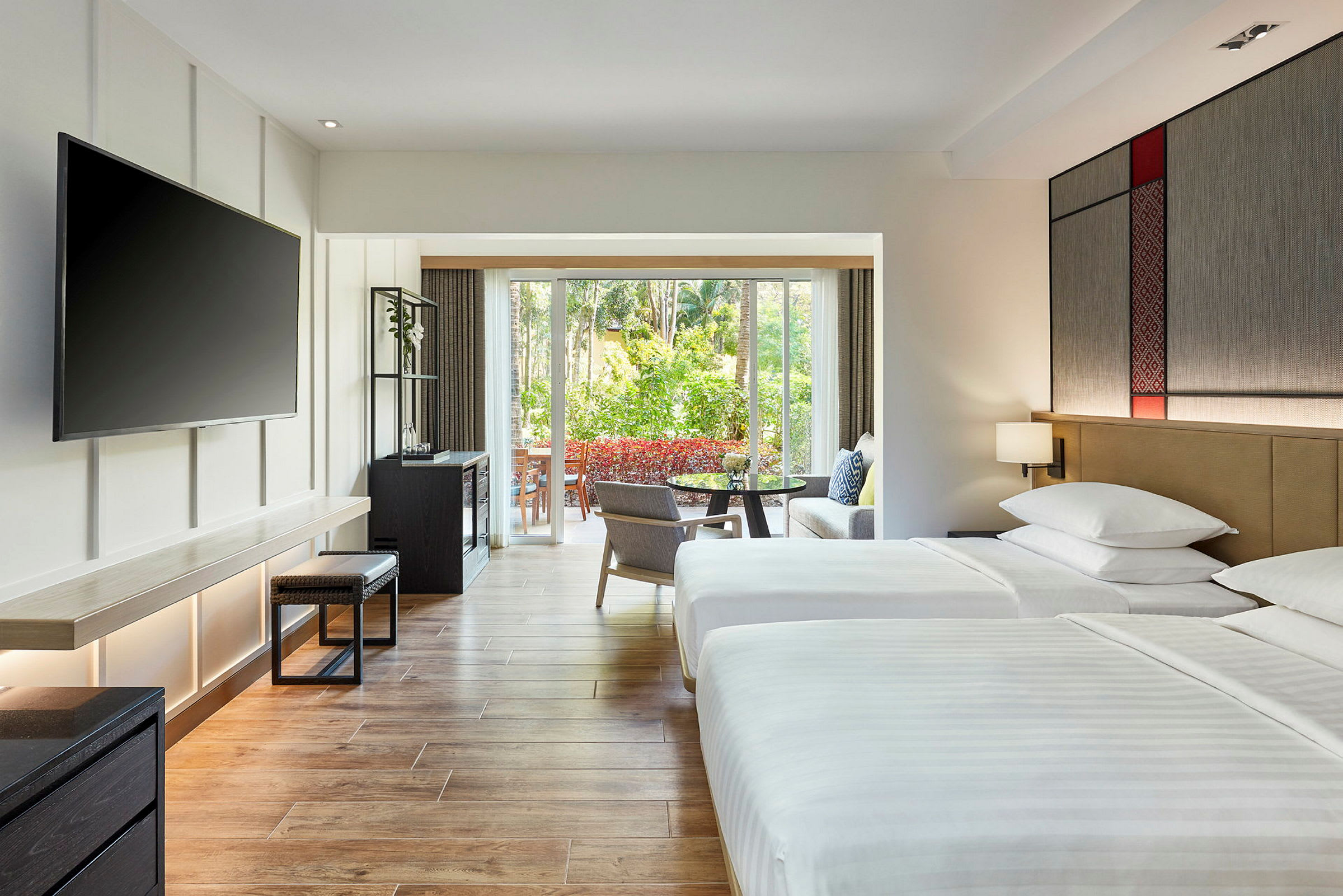 Hotellrom med to senger, et stort vindu som vender ut mot en frodig hage. (AI-generert tekst)