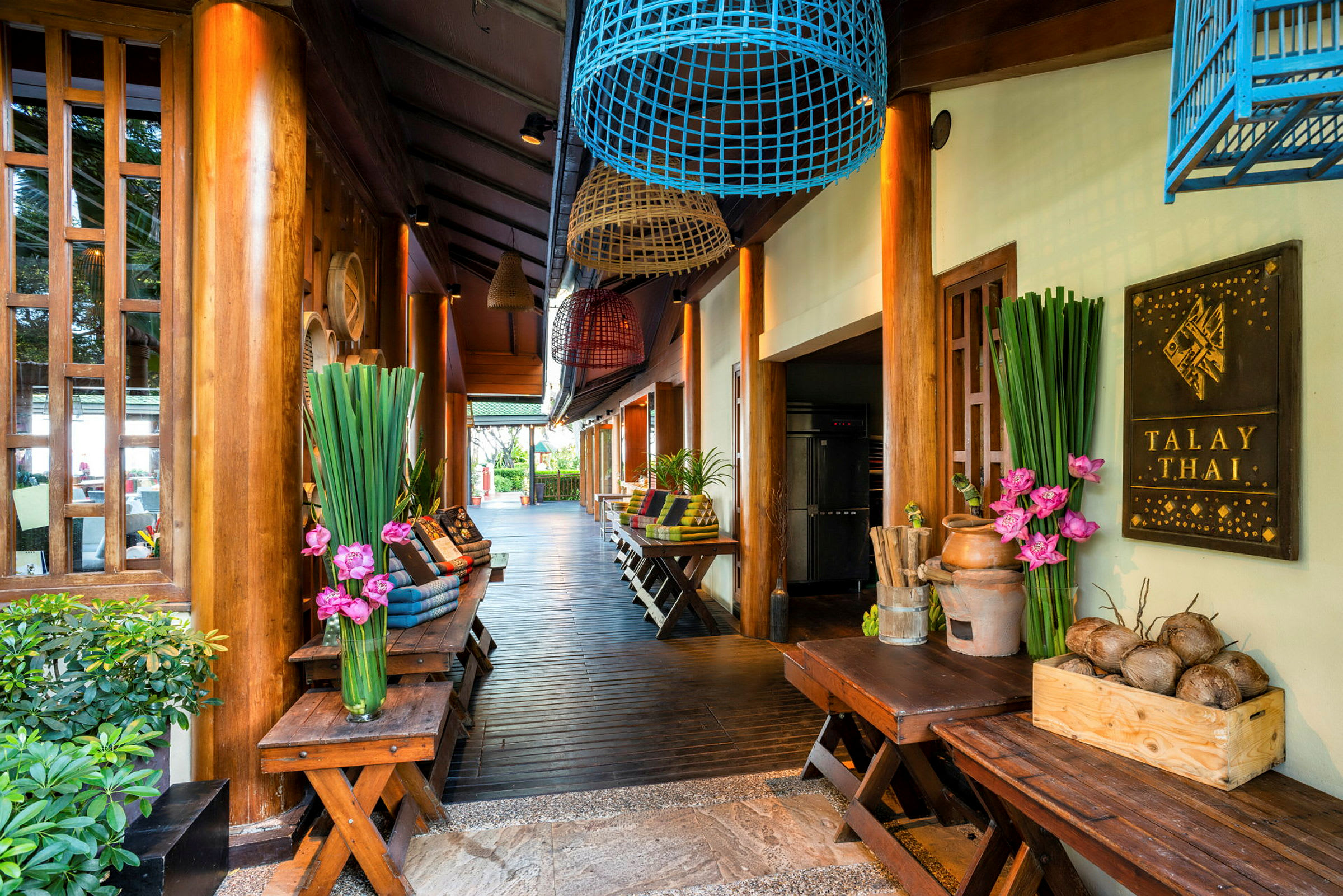 Inngang til en thai-restaurant med trematerialer, planter og dekorasjoner. (AI-generert tekst)