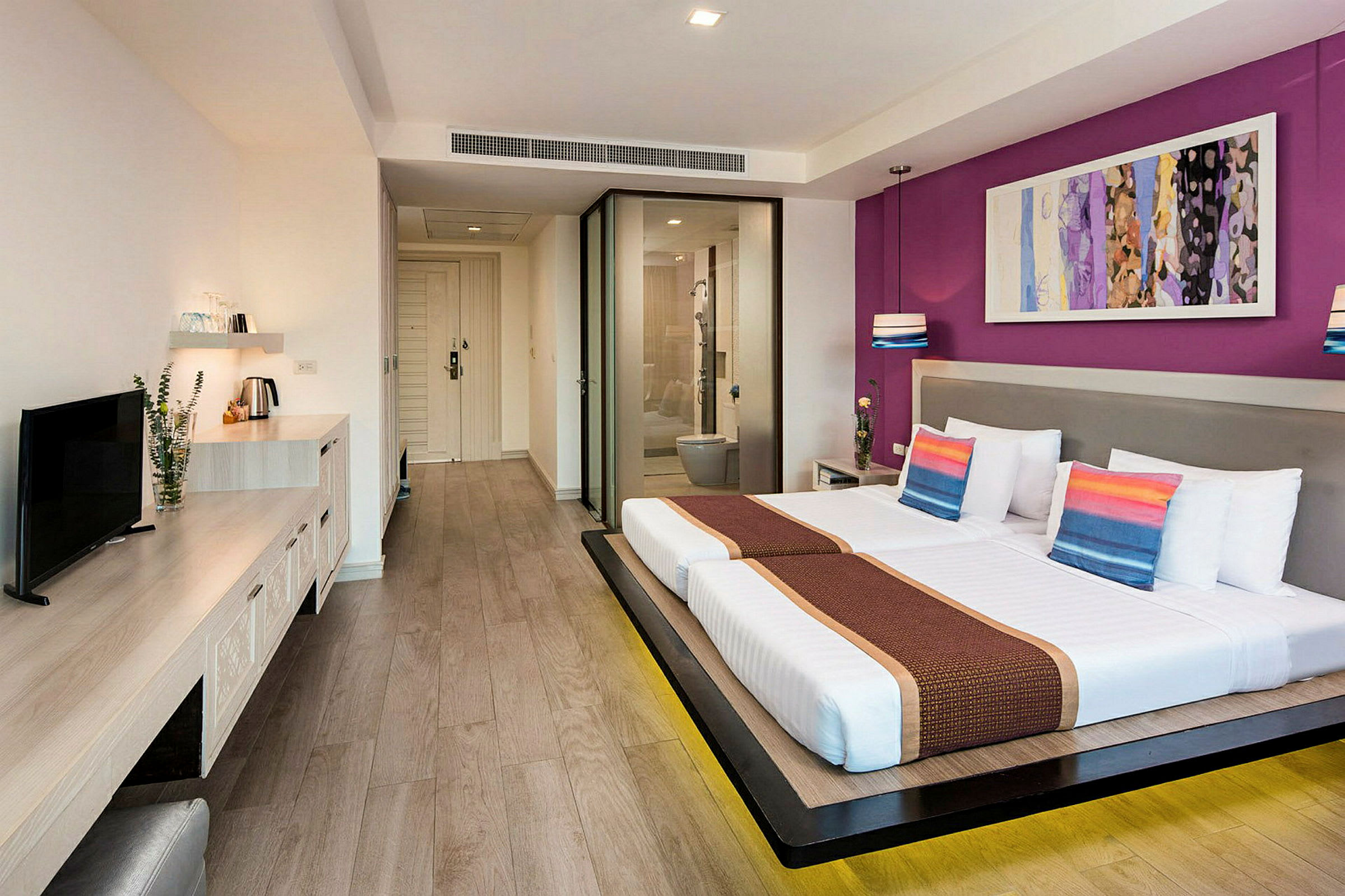 Et moderne hotellrom med to enkeltsenger, et skrivebord med TV og en glassvegg som skiller badet. (AI-generert tekst)