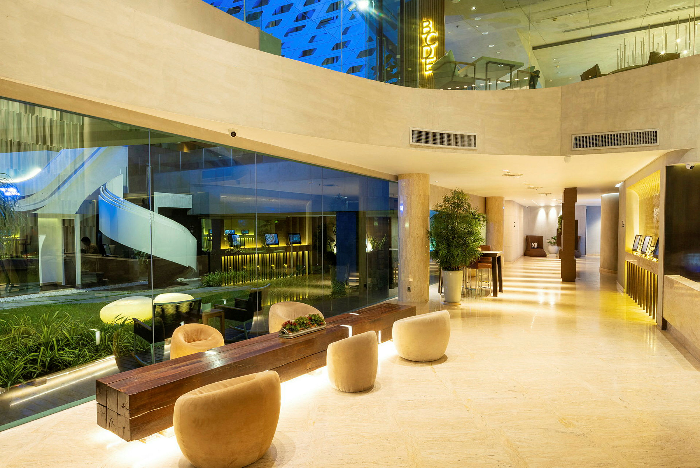Hotellobby med sitteplasser og glassvegger. (AI-generert tekst)