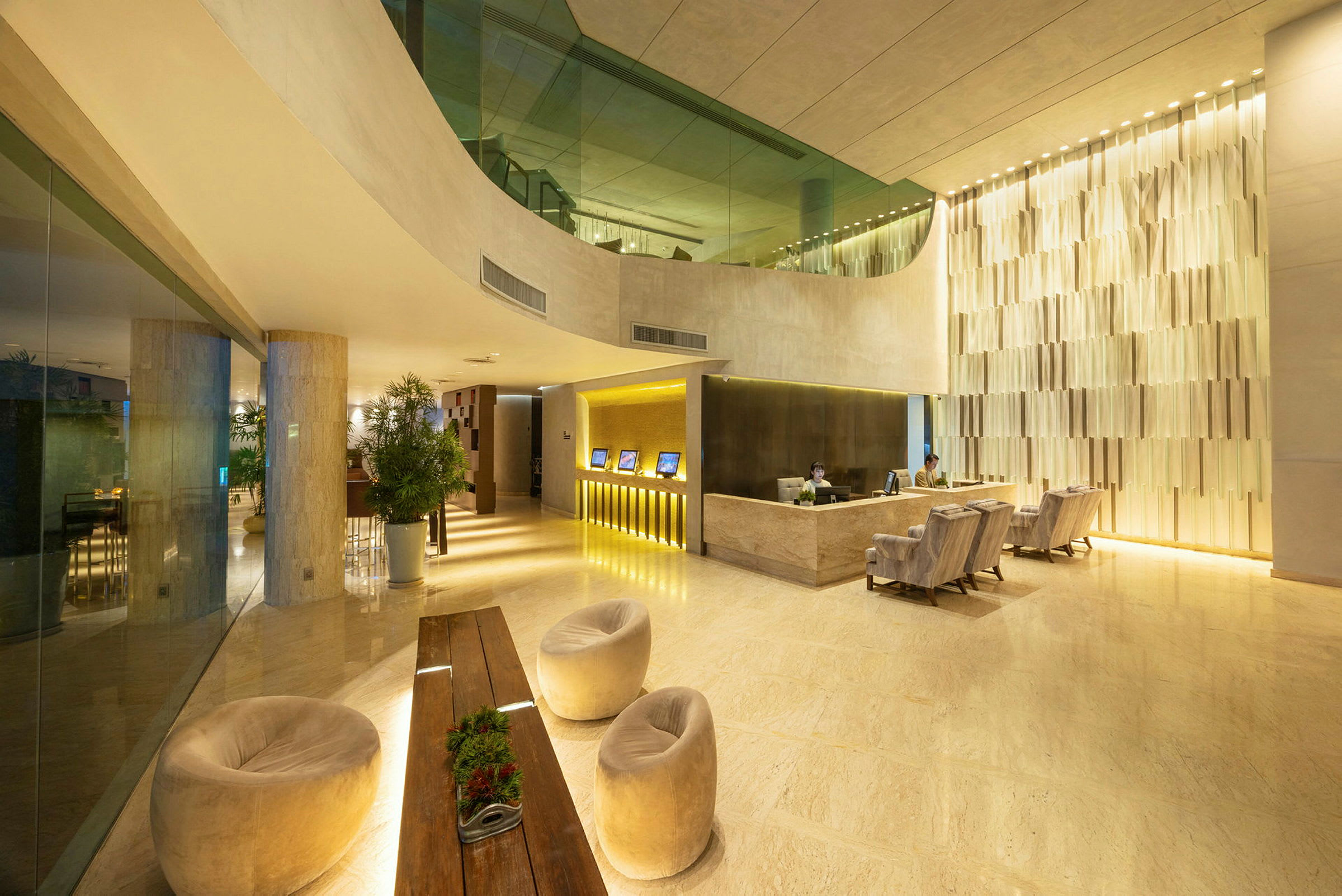 En moderne hotellobby med resepsjon, sitteplasser og dekorative planter. (AI-generert tekst)
