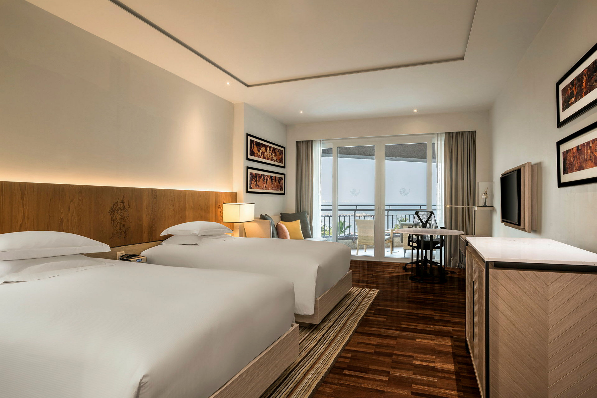 Hotellrom med to senger, moderne interiør og balkong i bakgrunnen. (AI-generert tekst)