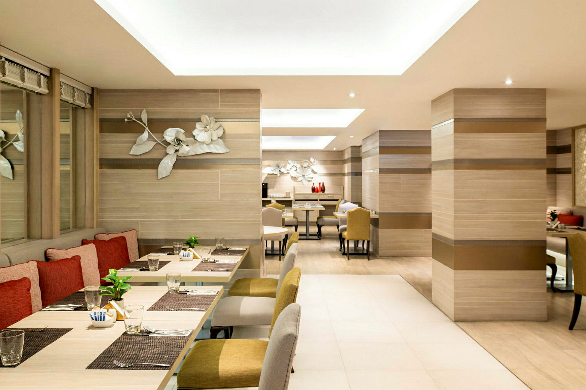 Et moderne og lyst innredet restaurantrom med sitteplasser og dekorasjoner på veggene. (AI-generert tekst)