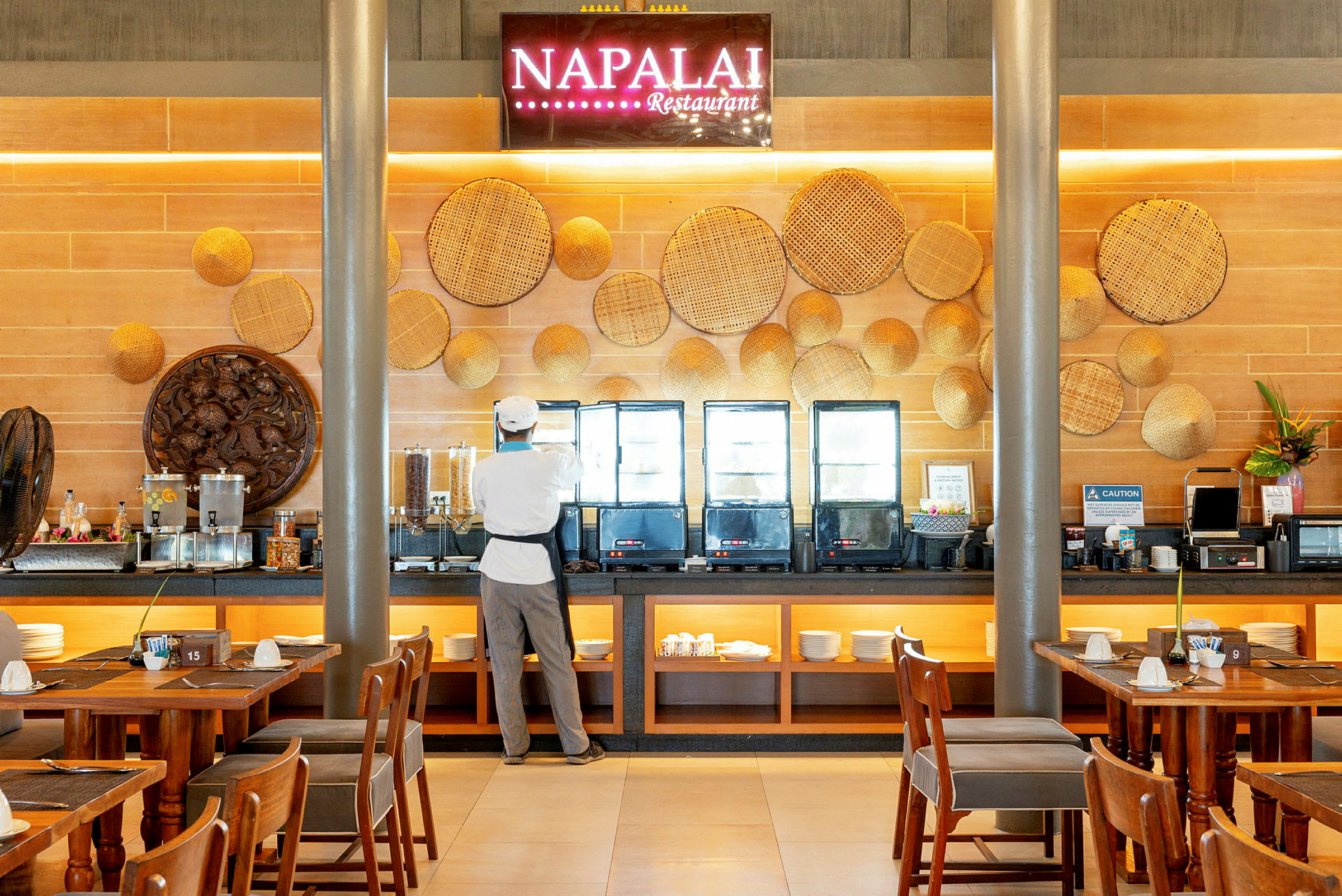 En kokk står ved en bufféoppsettning på restauranten Napalai. (AI-generert tekst)