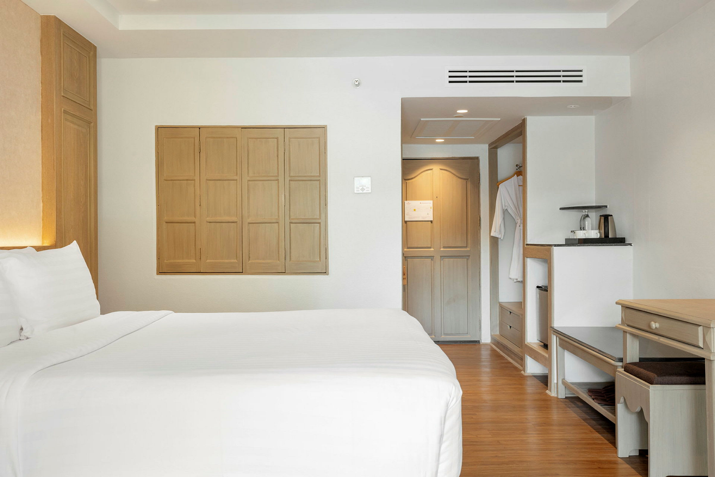 Hotellrom med dobbeltseng, sittemøbler og varm innredning. (AI-generert tekst)
