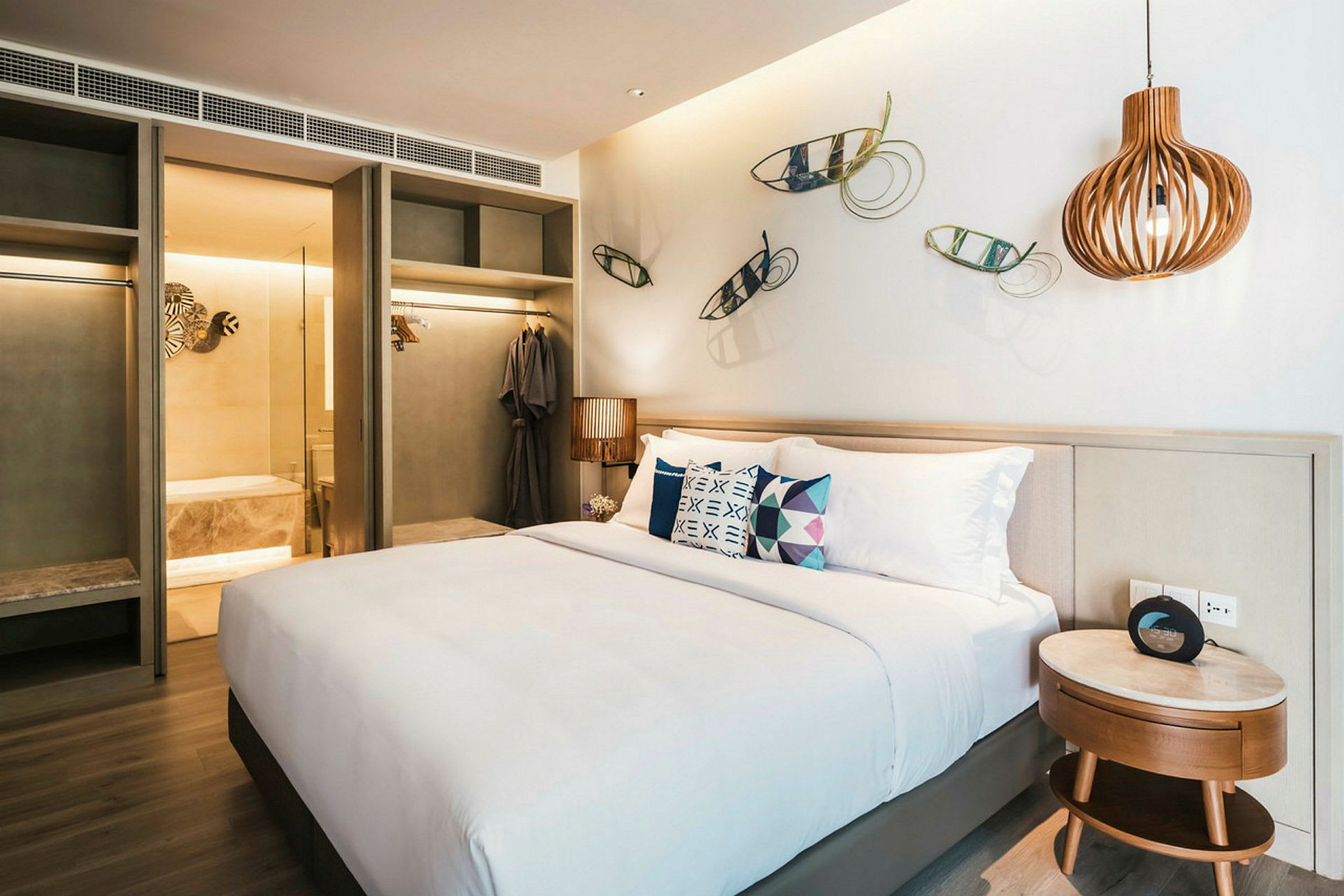 Bilde av et moderne hotellrom med en stor seng, dekorative veggdetaljer og et baderom i bakgrunnen. (AI-generert tekst)