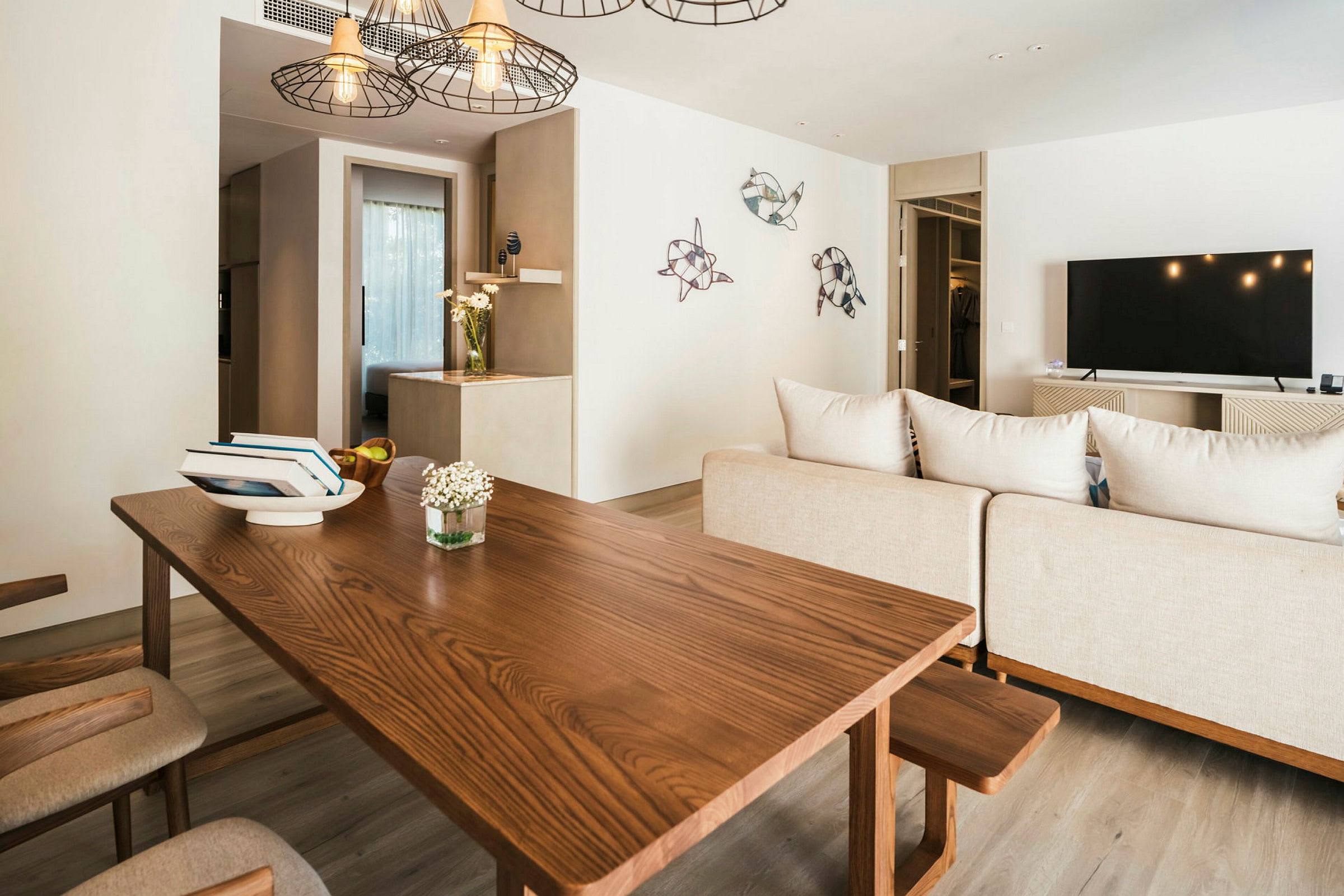 Interiør av en stue med et trebord, beige sofa, flatskjerm-TV og dekorasjoner på veggen. (AI-generert tekst)