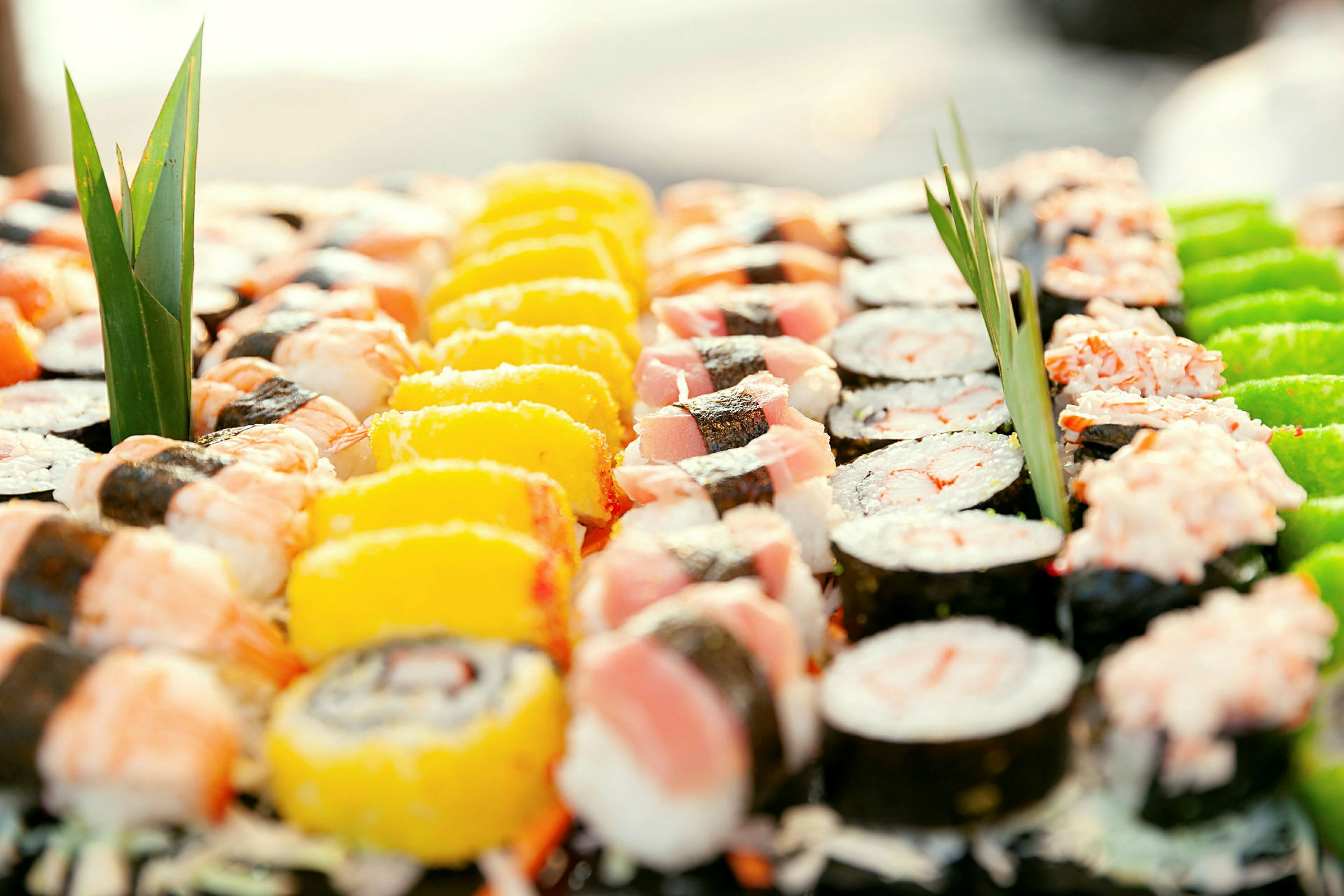 Et nærbilde av ulike typer sushi, dandert med dekorative blader. (AI-generert tekst)