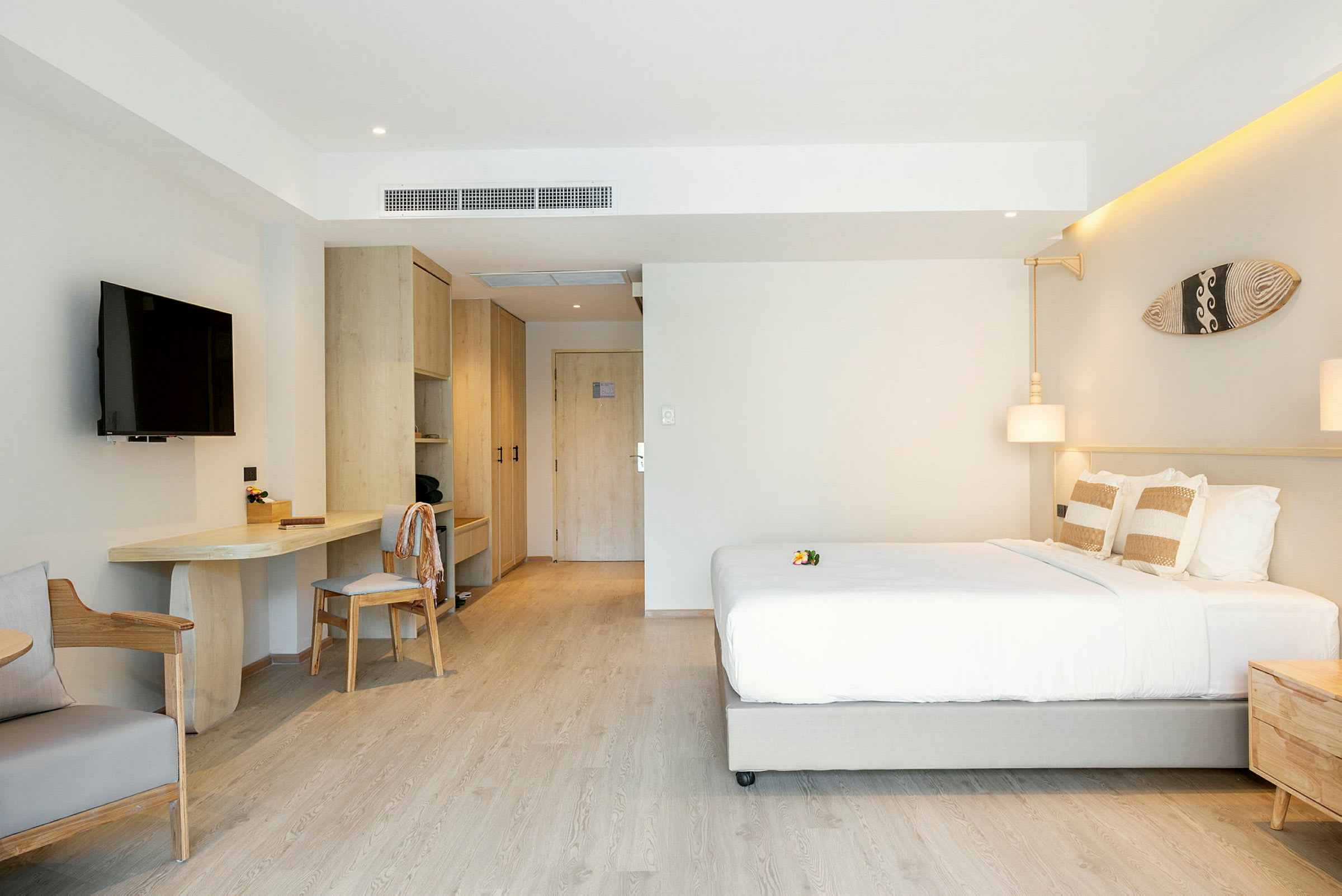 Et moderne hotellrom med en dobbeltseng, TV, skrivebord og garderober. (AI-generert tekst)