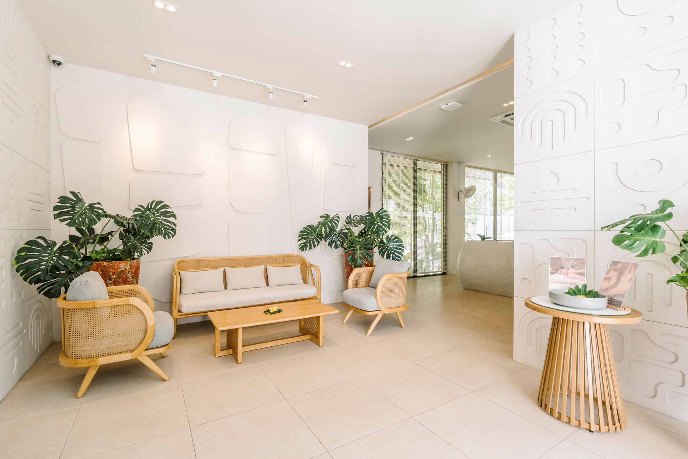 Lys og moderne lobby med planter og sittegrupper i lyst tre-design. (AI-generert tekst)