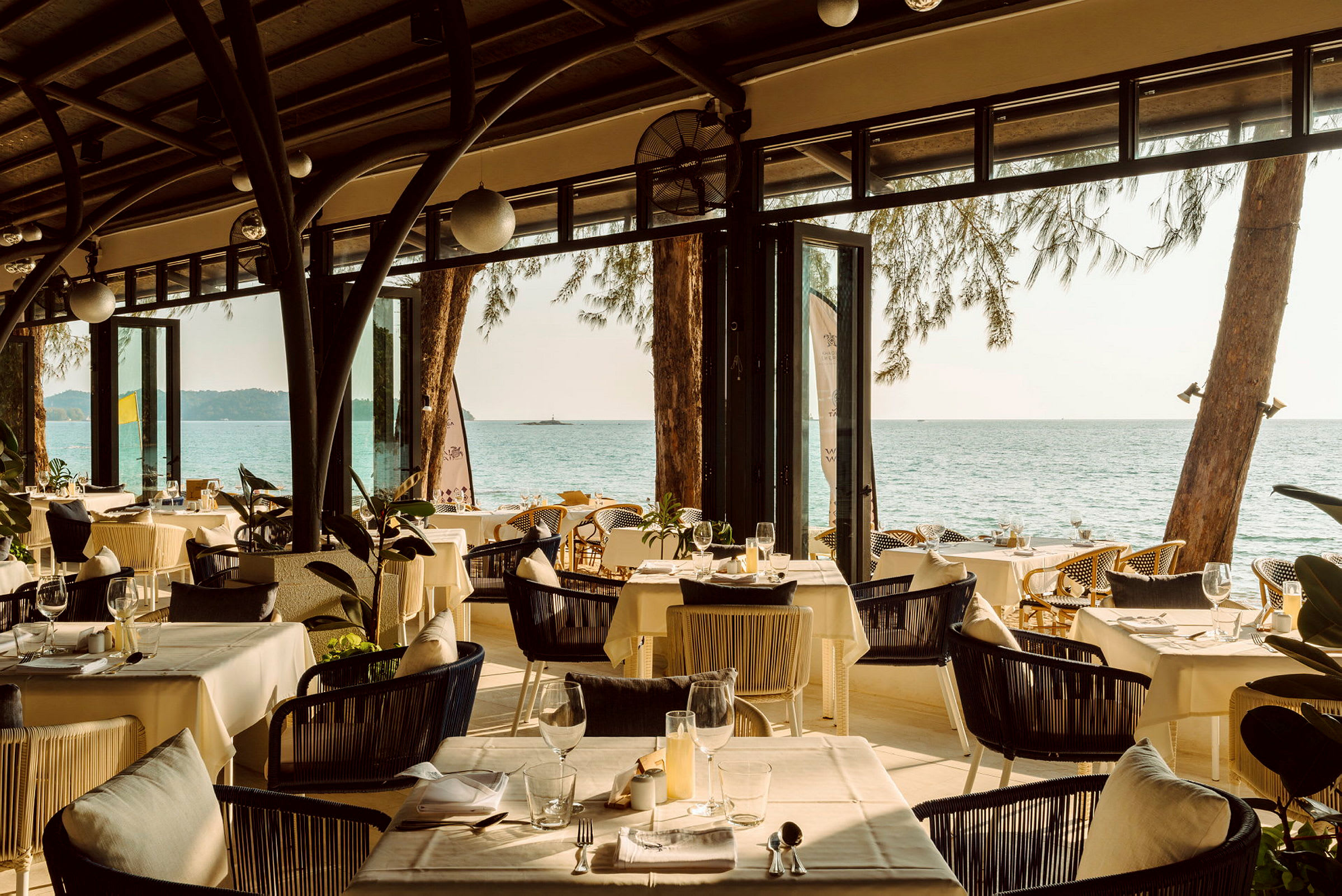 En restaurant med dekkede bord og utsikt over havet. (AI-generert tekst)