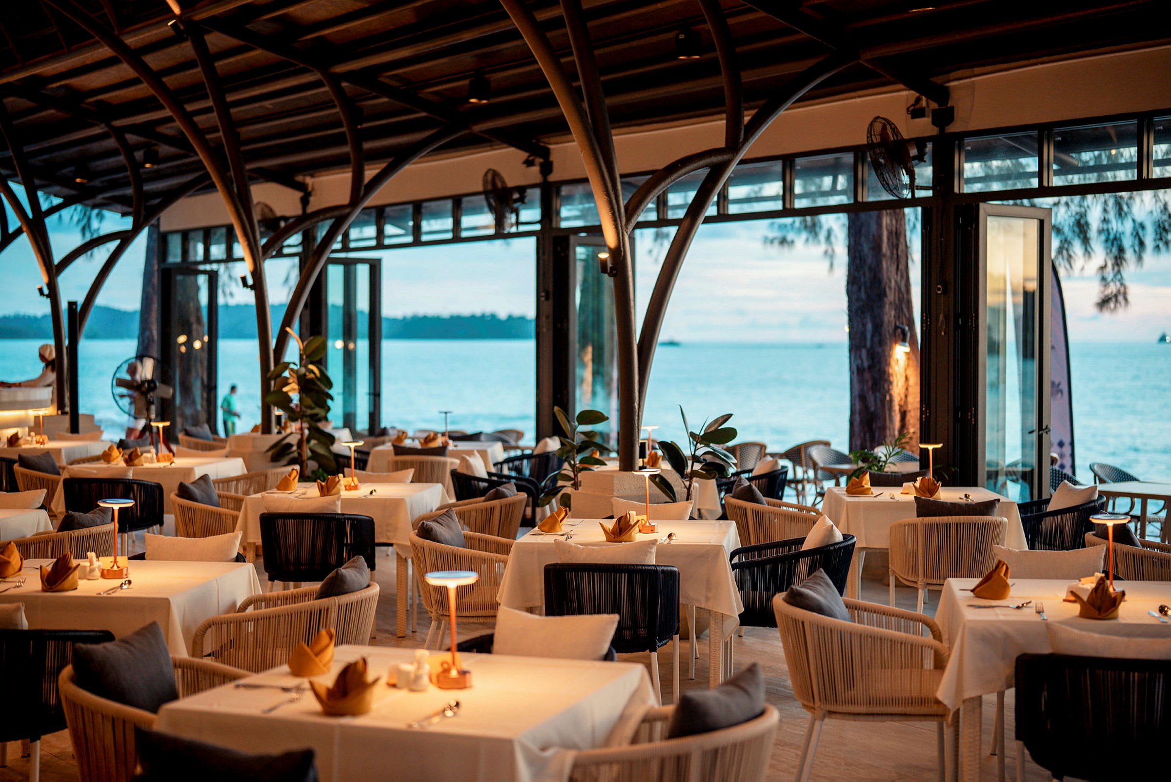 En elegant restaurant med dekkede bord og havutsikt. (AI-generert tekst)