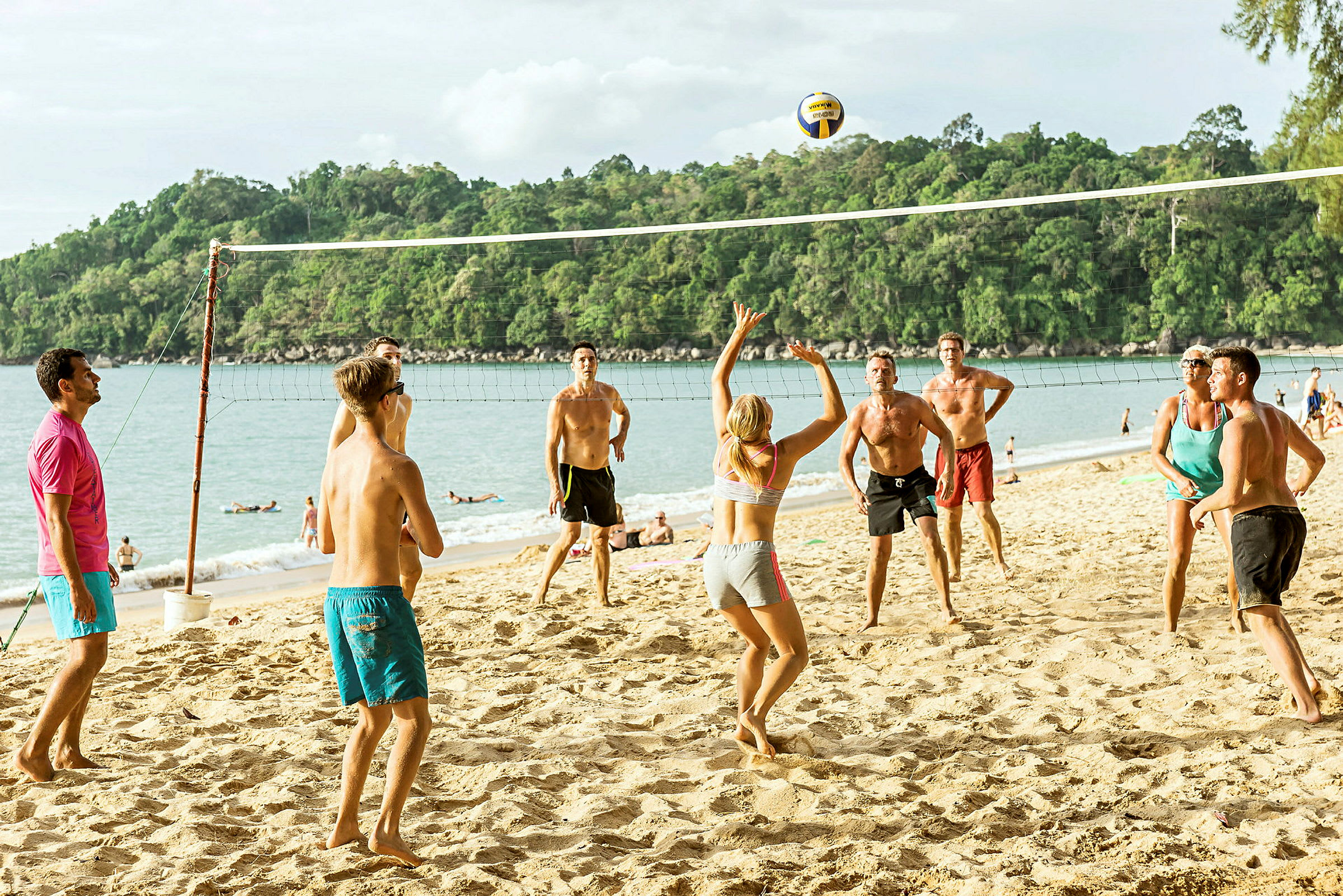 Personer spiller volleyball på en strand. (AI-generert tekst)