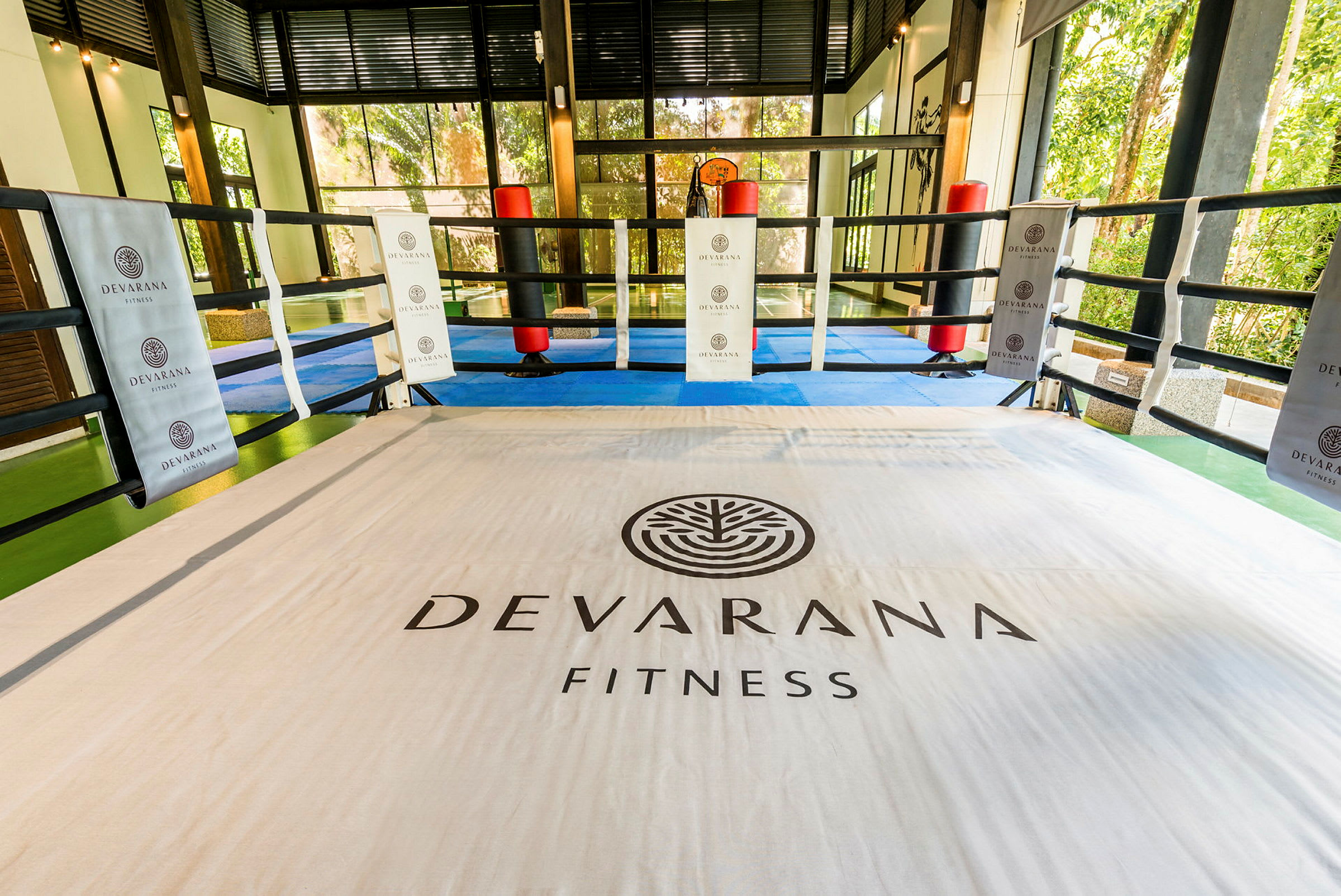 En innendørs treningsring merket med teksten "Devarana Fitness", omgitt av tau. (AI-generert tekst)