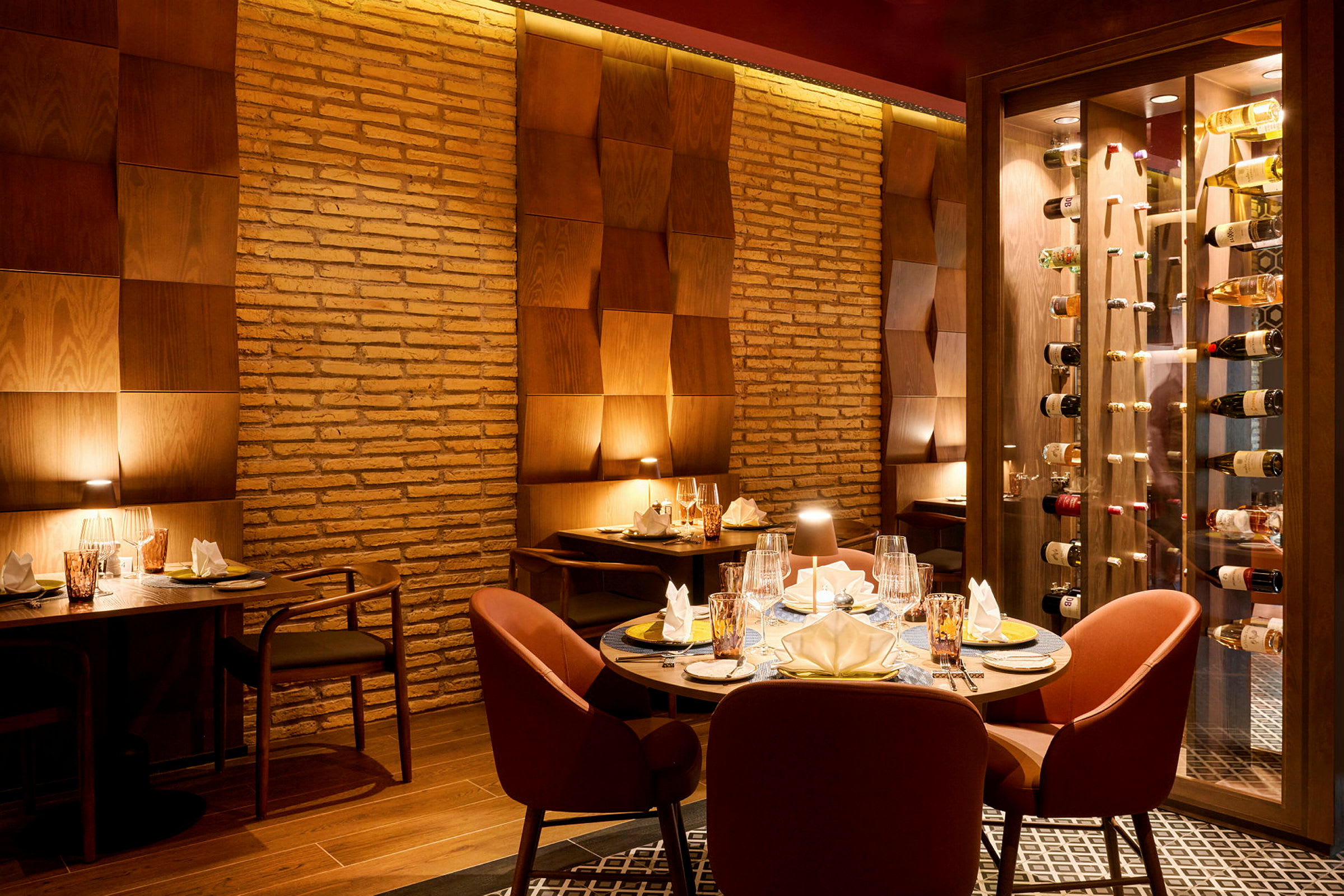 En elegant restaurantinteriør med dekkede bord og myk belysning mot vegger av teglstein og trepanel. (AI-generert tekst)