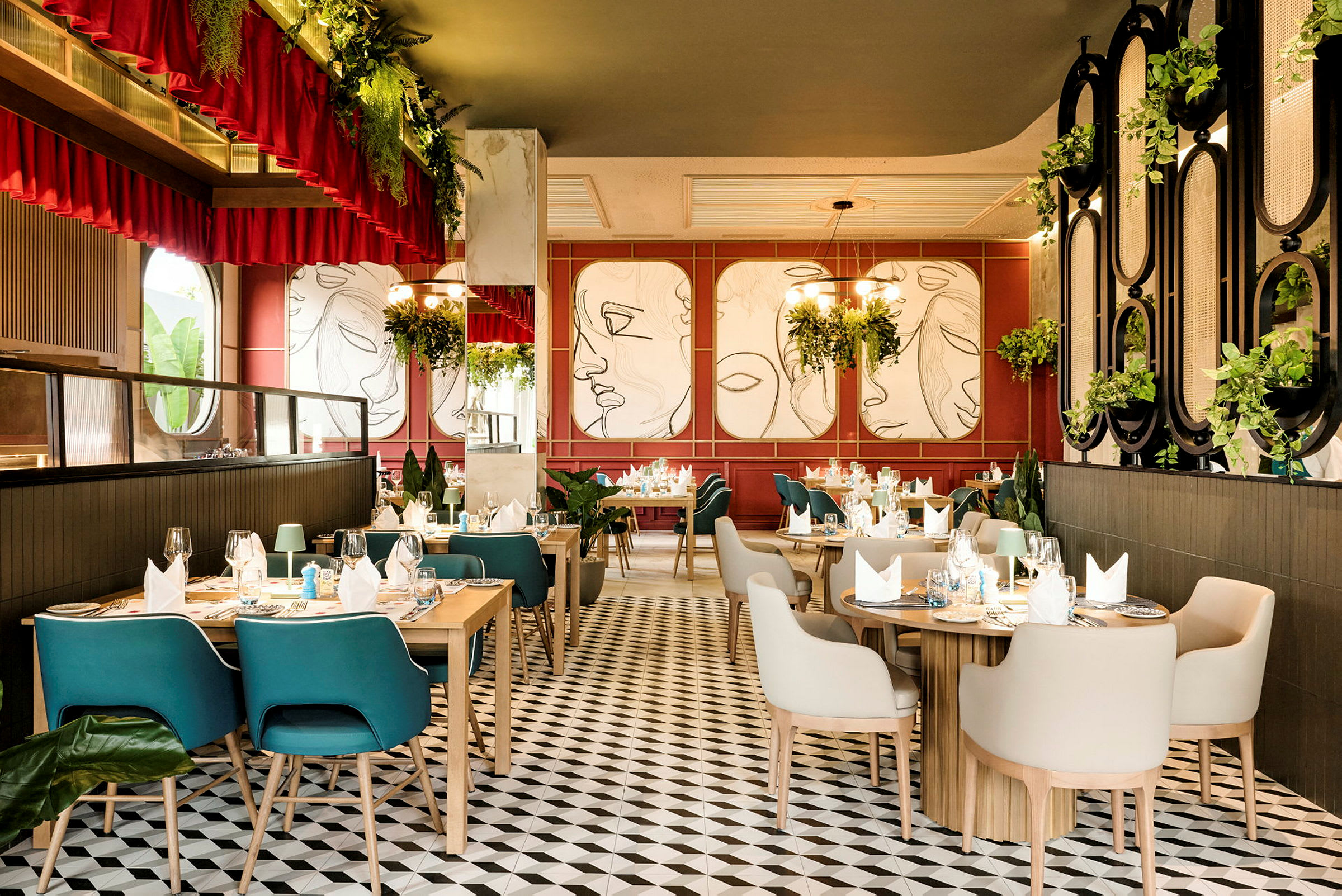 En elegant innredet restaurant med trebord, komfortable stoler og moderne veggkunst på veggene. Rommet har mye grønt og takbelysning. (AI-generert tekst)