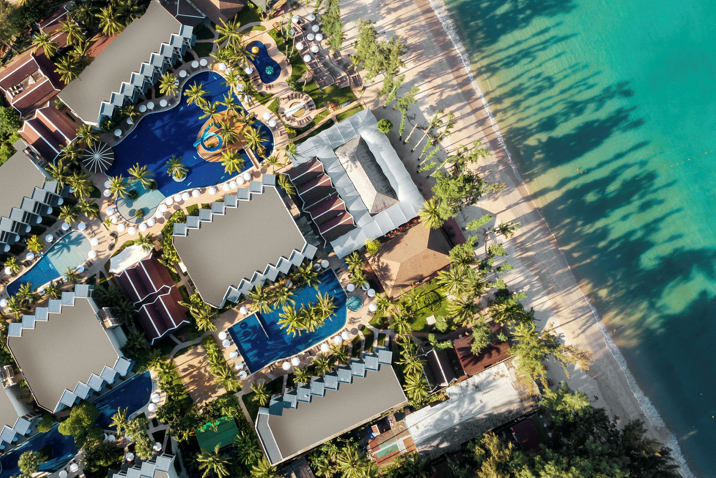 Fugleperspektiv av en ferieresort ved en strand. (AI-generert tekst)