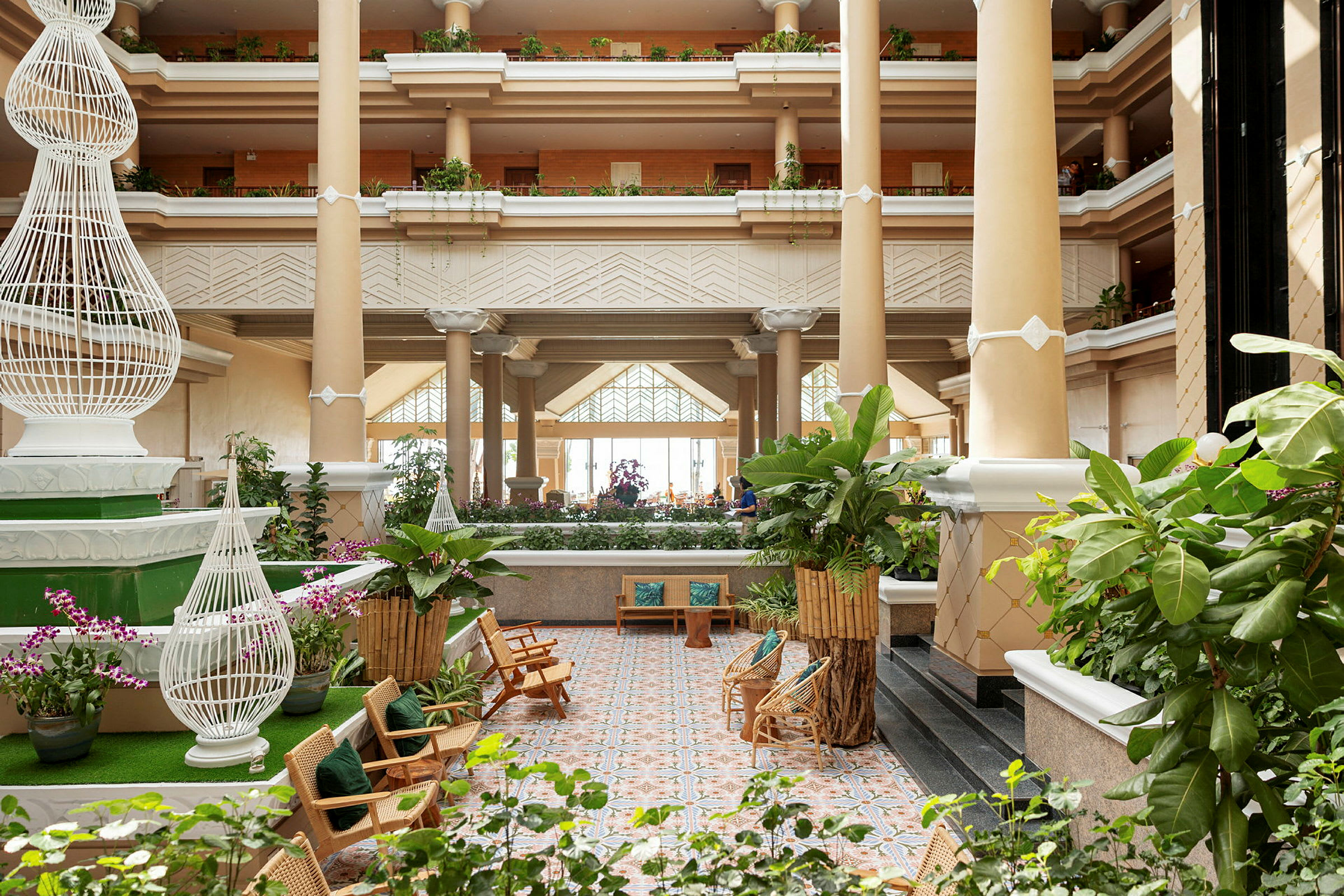 Lys og romslig hotellobby med grønne planter og sitteplasser. (AI-generert tekst)