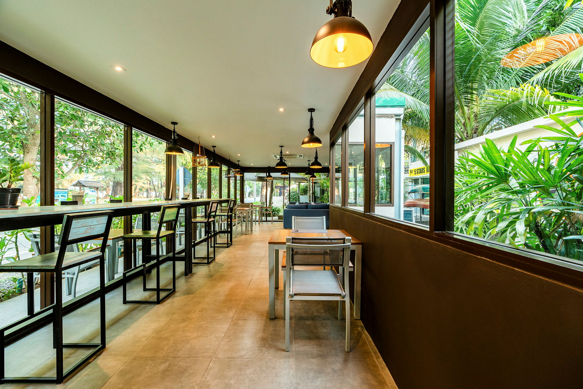 En moderne restaurant med store glassvinduer og utsikt over grøntområder. (AI-generert tekst)