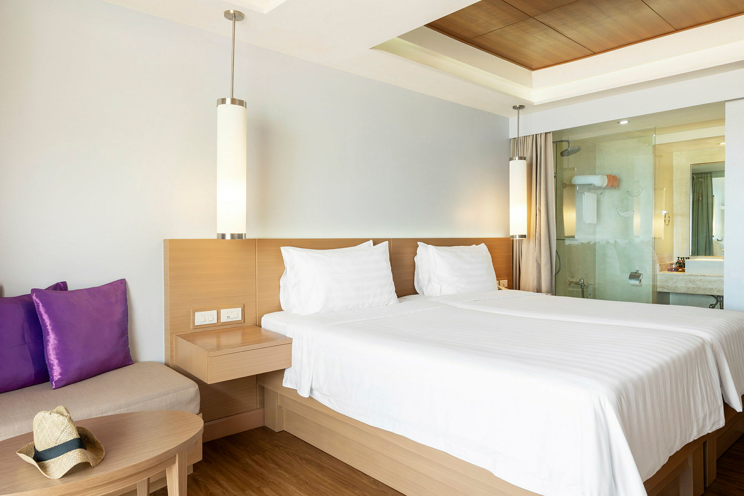 Hotellrom med dobbeltseng, sofa og bad. (AI-generert tekst)