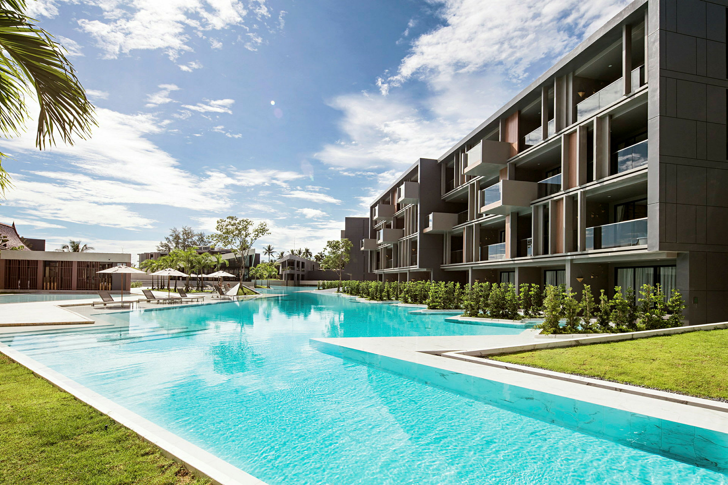 Et moderne hotell med bassengområde og solsenger under parasoller. (AI-generert tekst)