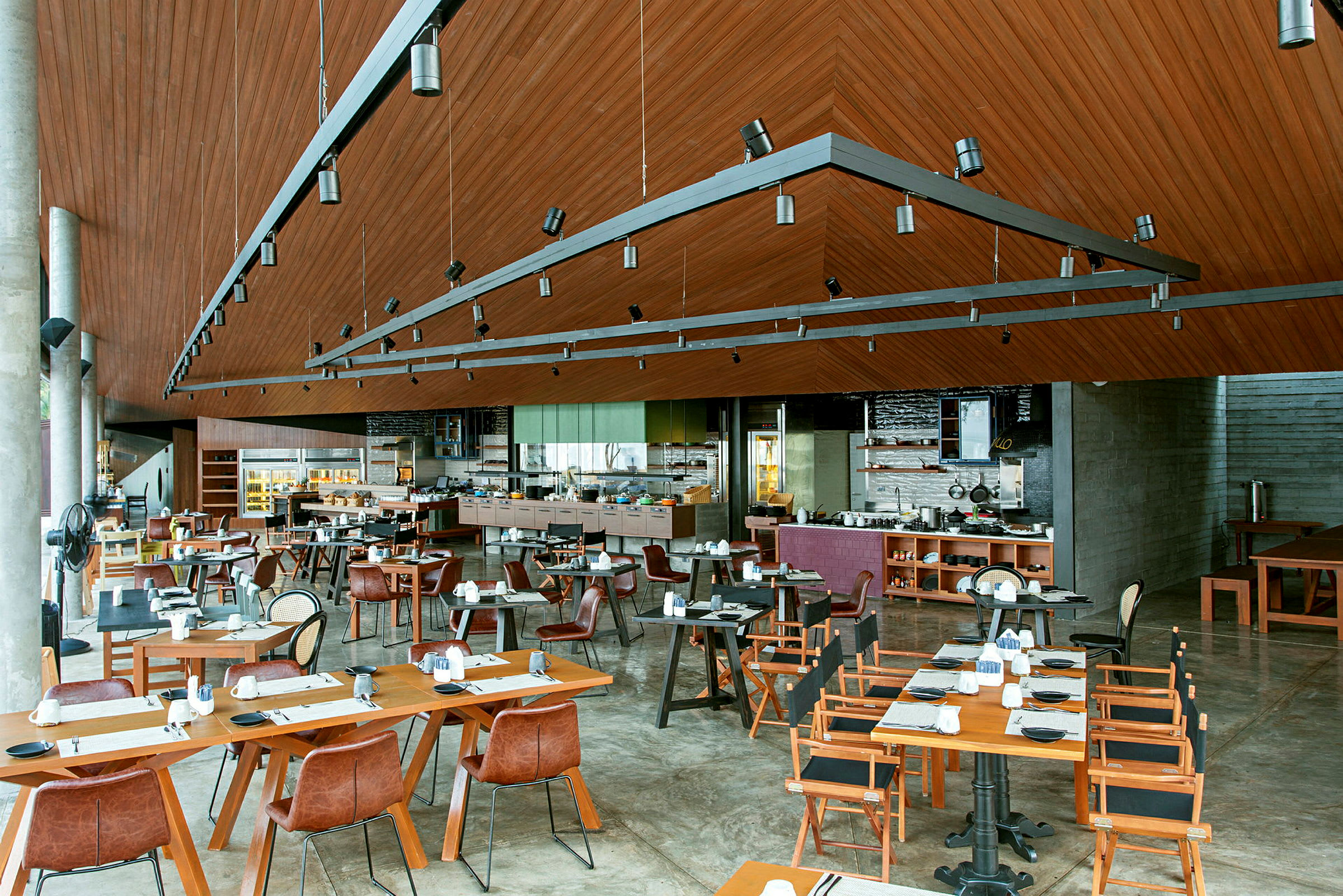 En romslig restaurant med tredetaljer, moderne møbler og dekkede bord. (AI-generert tekst)