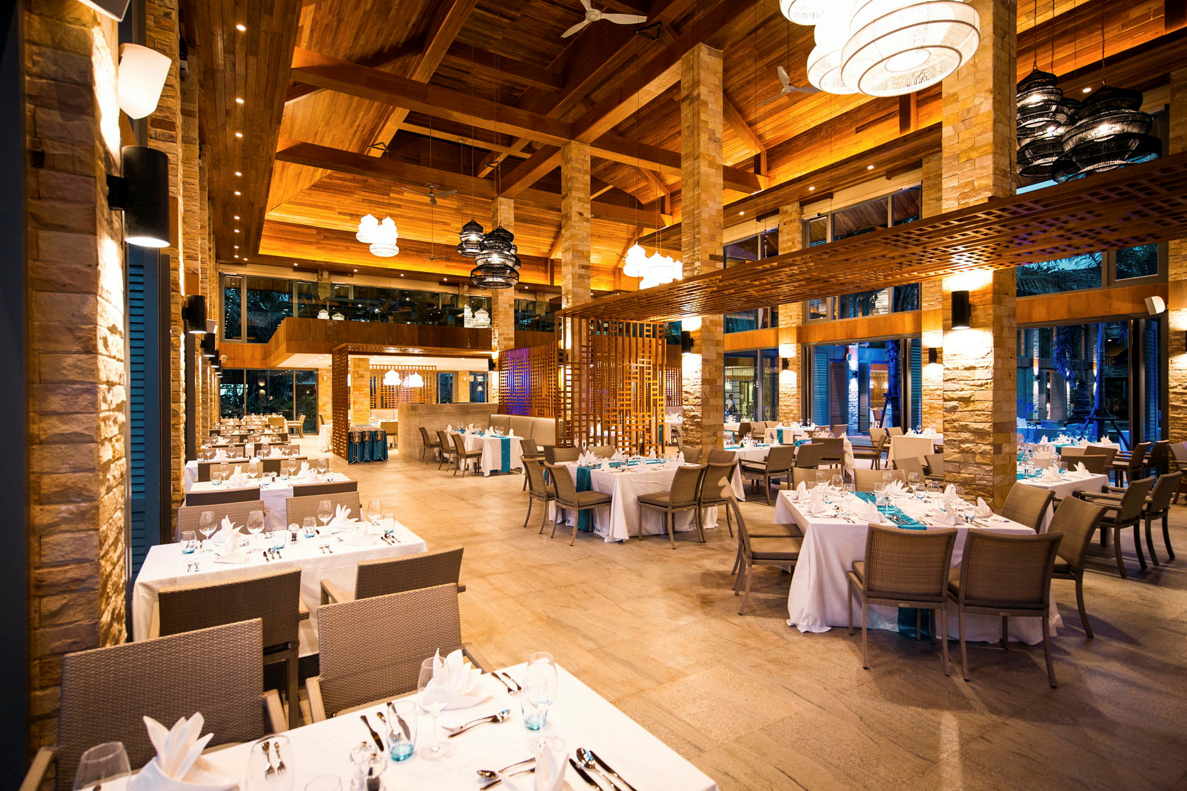 Interiør av en elegant restaurant med dekkede bord og moderne lamper. (AI-generert tekst)
