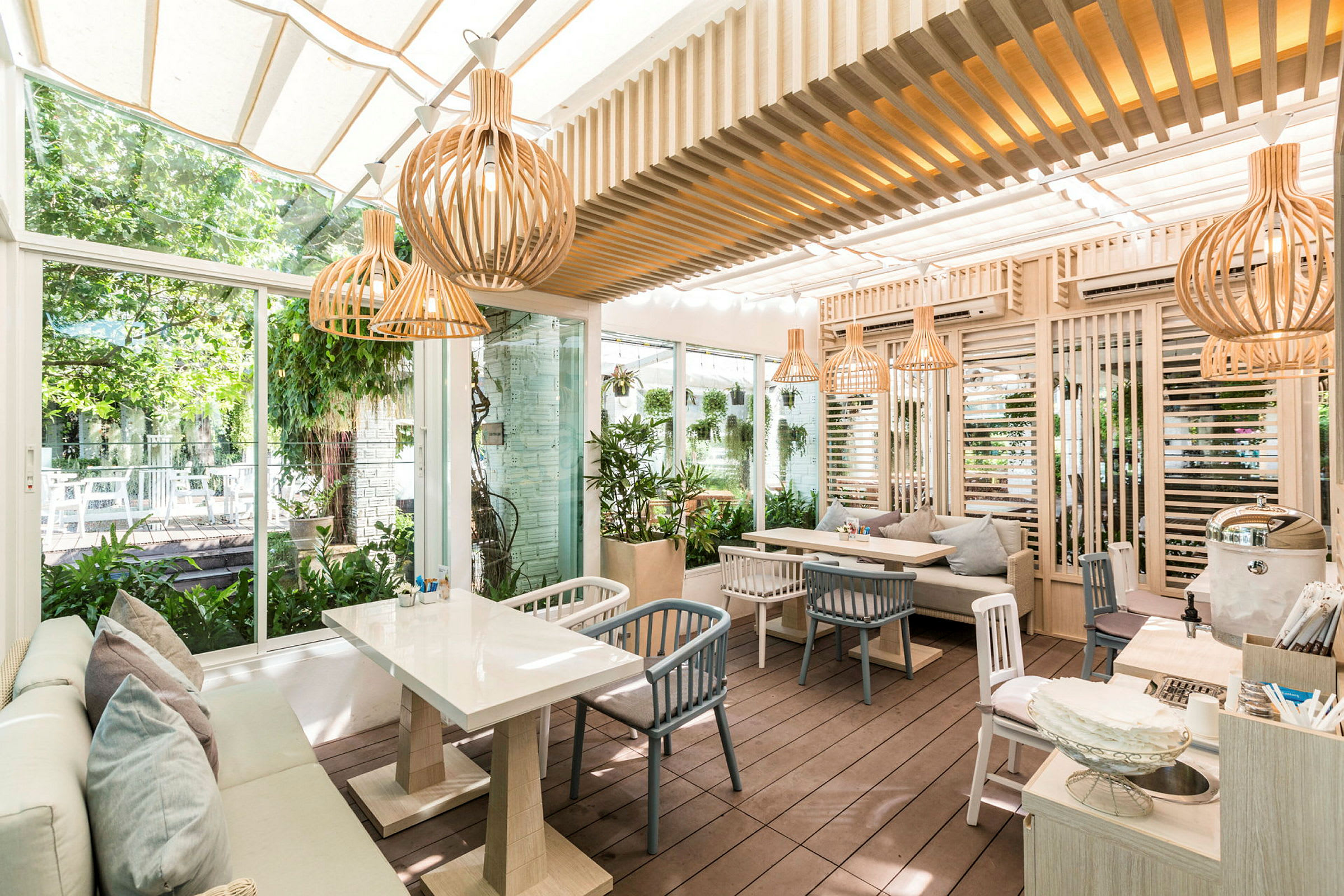 En moderne uterestaurant med naturmaterialer og planter. (AI-generert tekst)