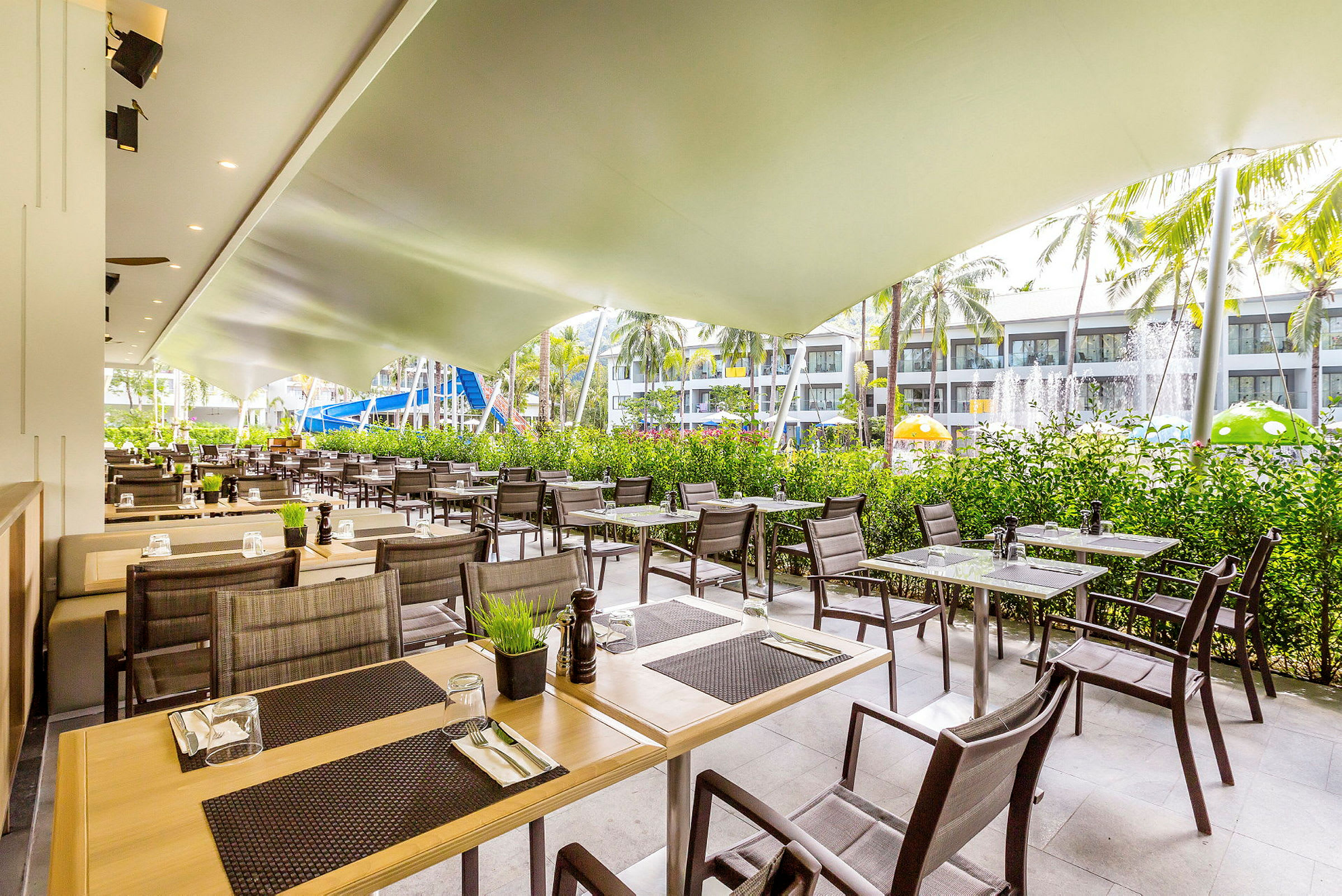 Utendørs restaurant med bord og stoler under et tak. (AI-generert tekst)
