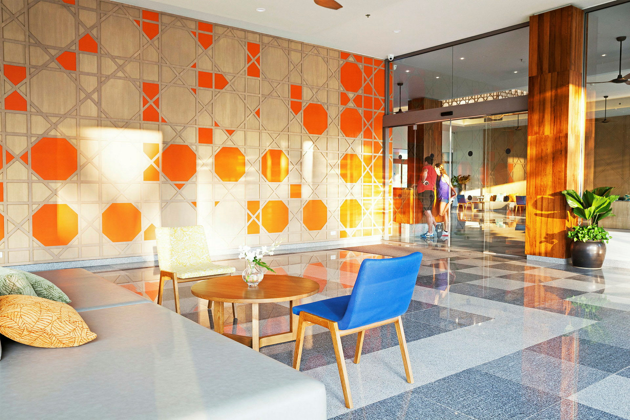 Lobbyen med en oransje og beige veggdesign og sittemøbler. (AI-generert tekst)