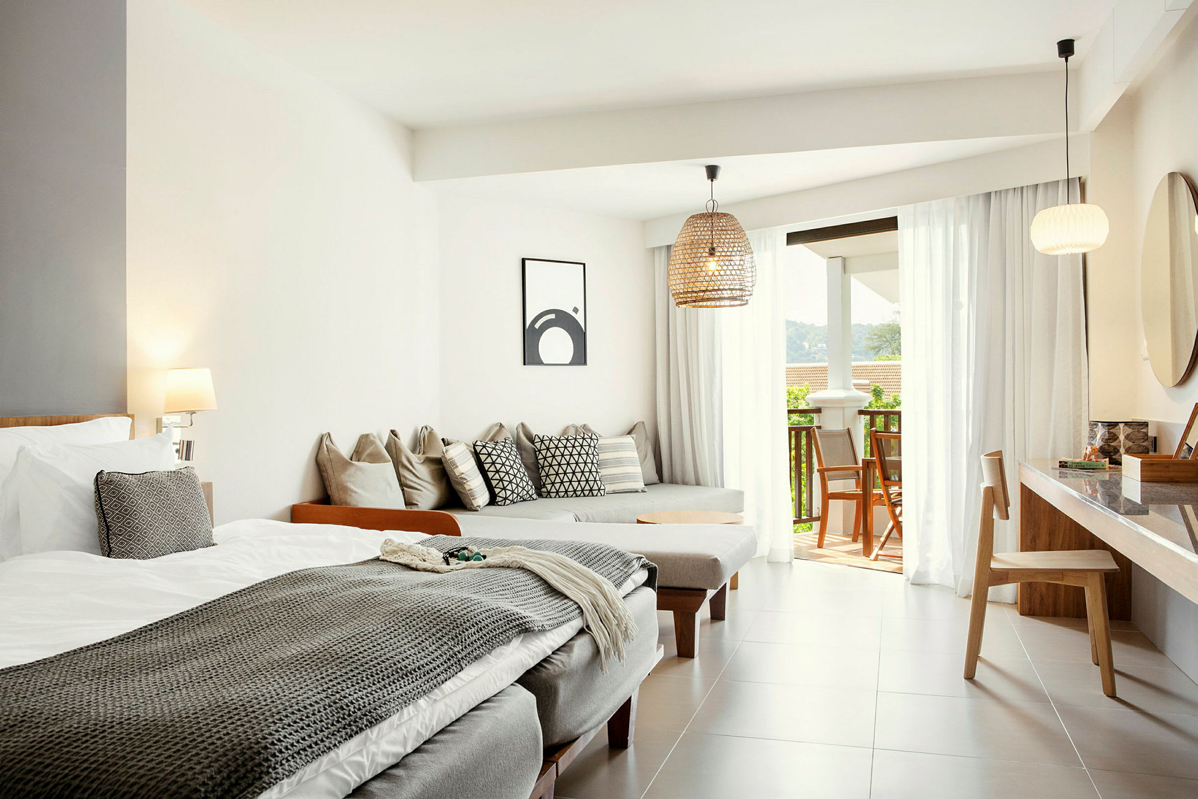 Lyse og moderne hotellrom med seng, sittemøbler og utgang til balkong. (AI-generert tekst)