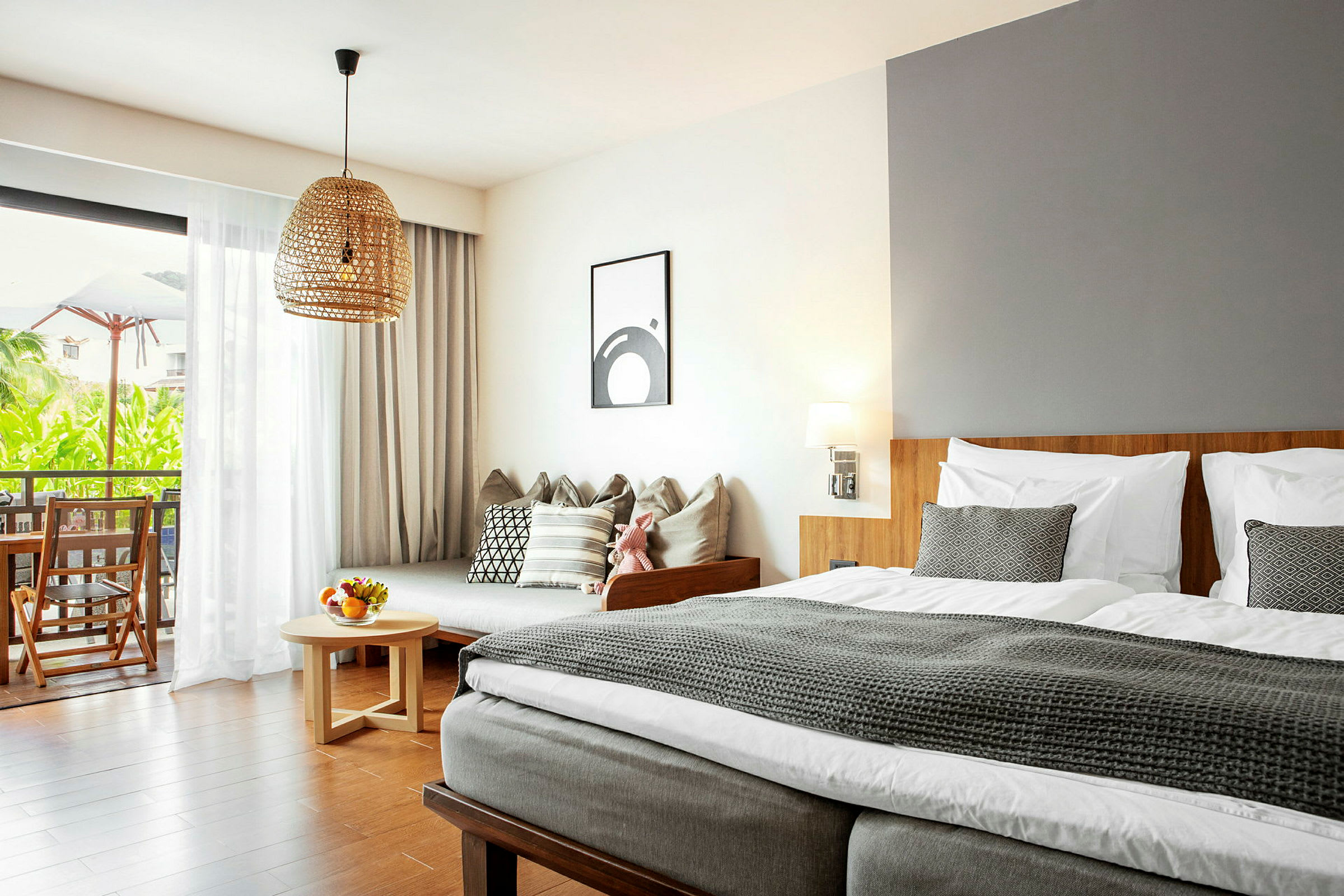 Moderne innredet hotellrom med seng, sofa og balkong med utsikt. (AI-generert tekst)