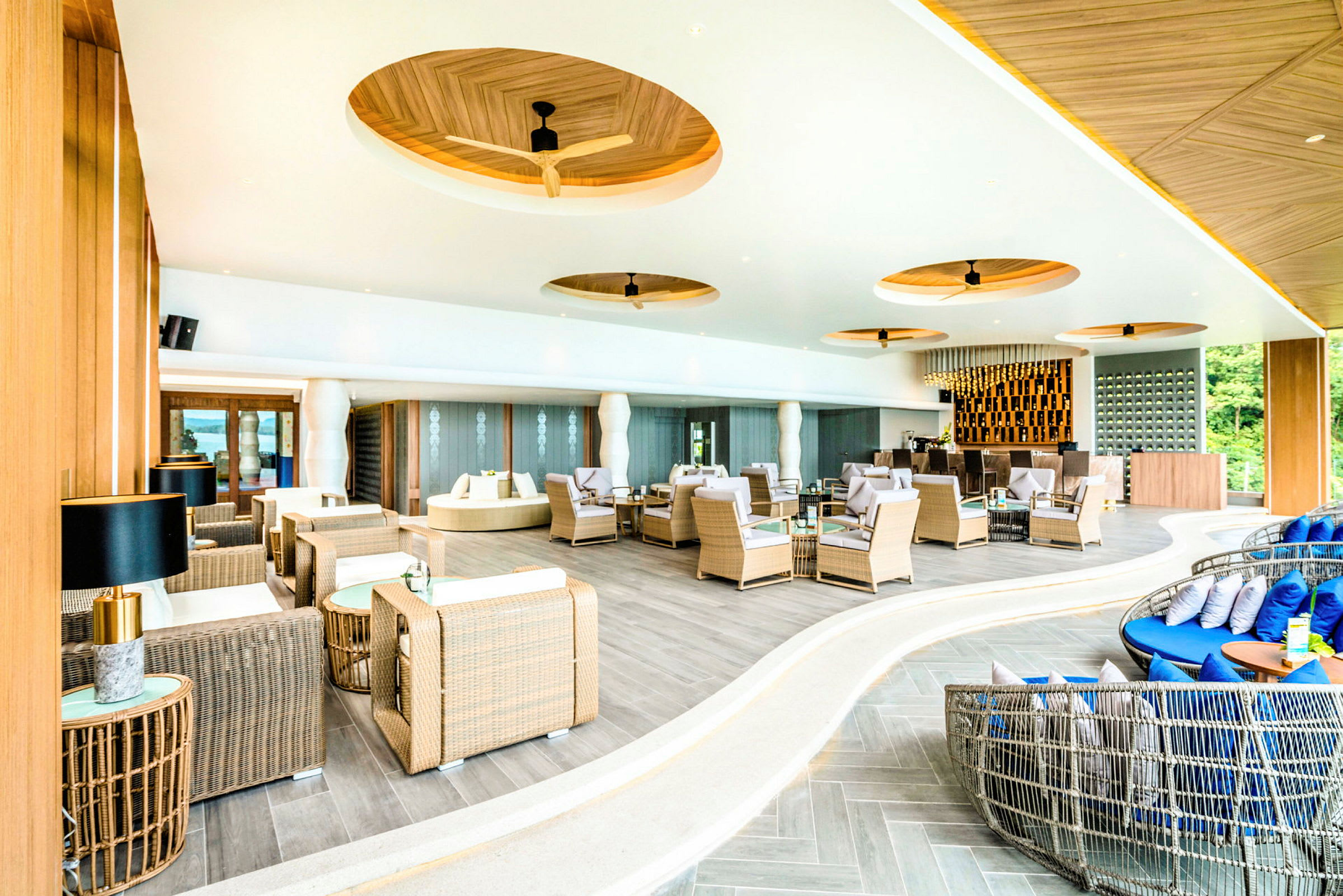 Moderne innredet lounge med rottingmøbler og elegant design. (AI-generert tekst)