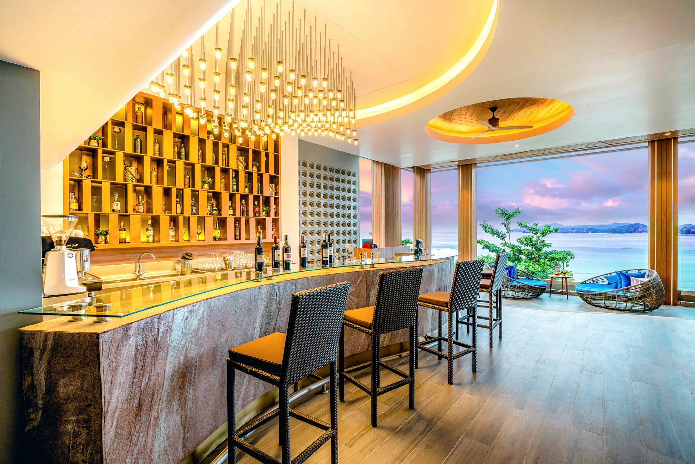 En hotellbar med stoler og et panoramavindu som viser havutsikt. (AI-generert tekst)