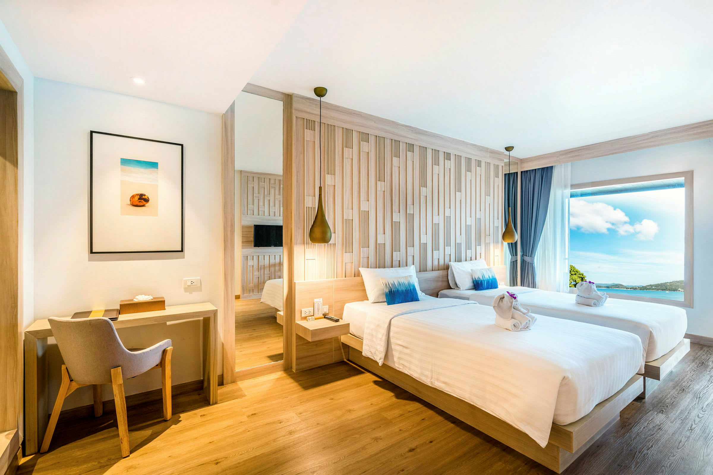 Moderne innredet hotellrom med to enkeltsenger, skrivebord og stort vindu med utsikt. (AI-generert tekst)