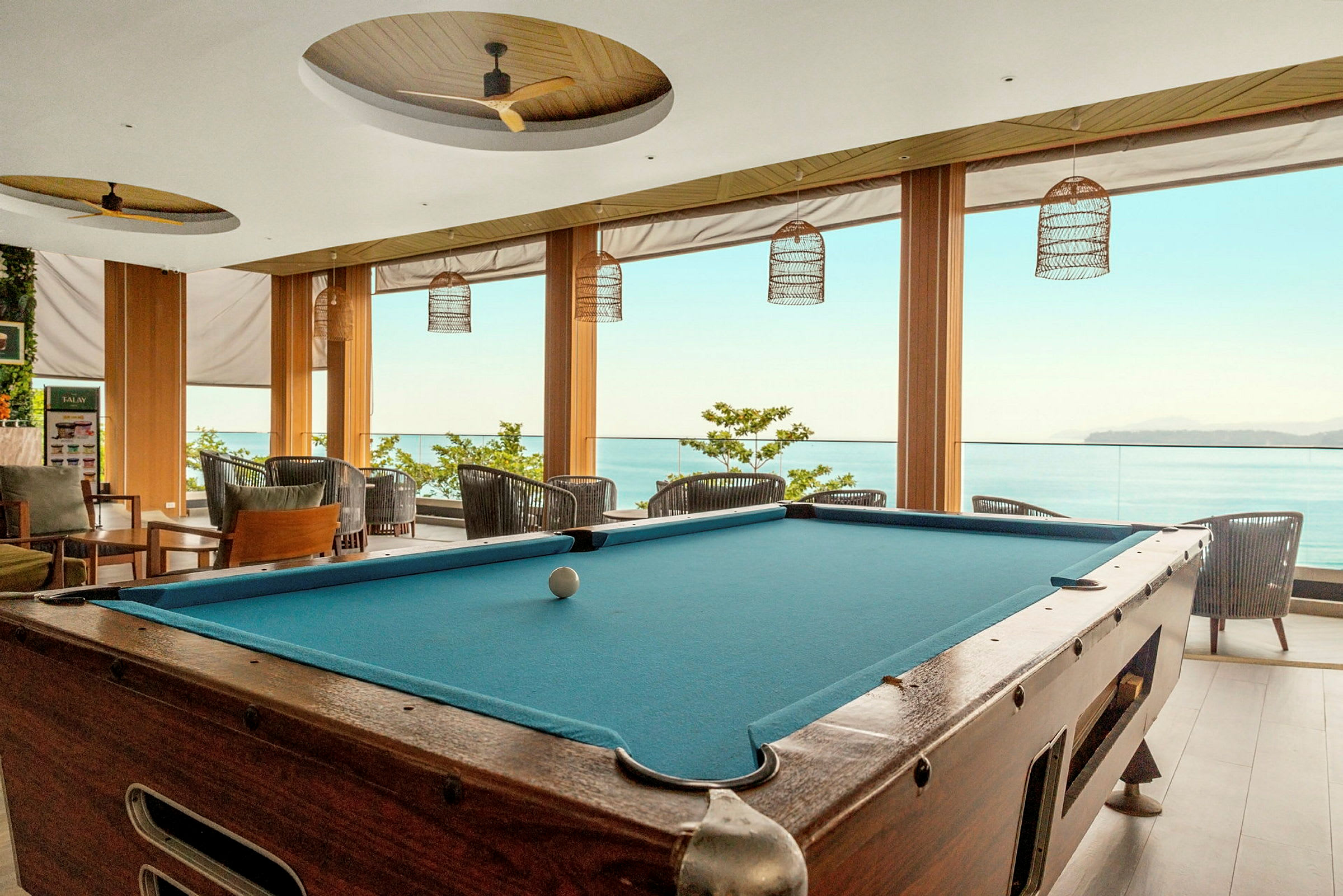 Biljardbord i en lys lounge med utsikt mot havet. (AI-generert tekst)